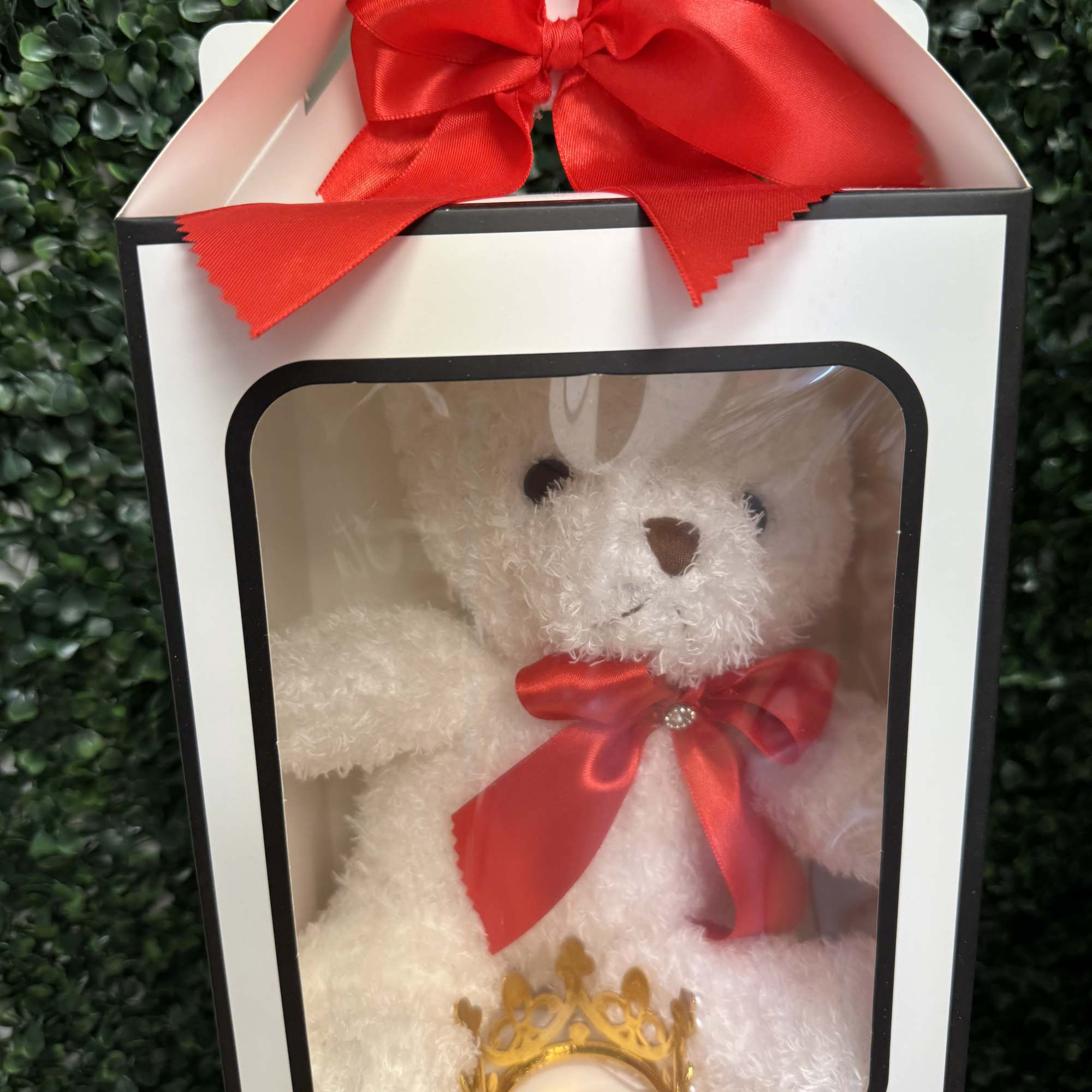 White teddy bear in a gift box with a red bow