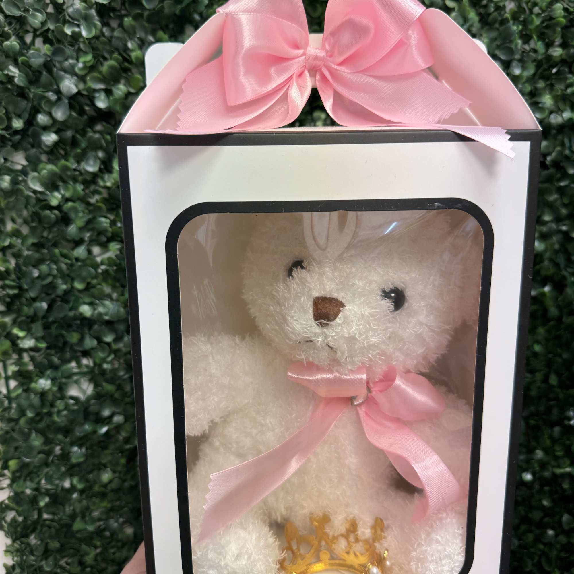 White teddy bear in a gift box with a pink bow