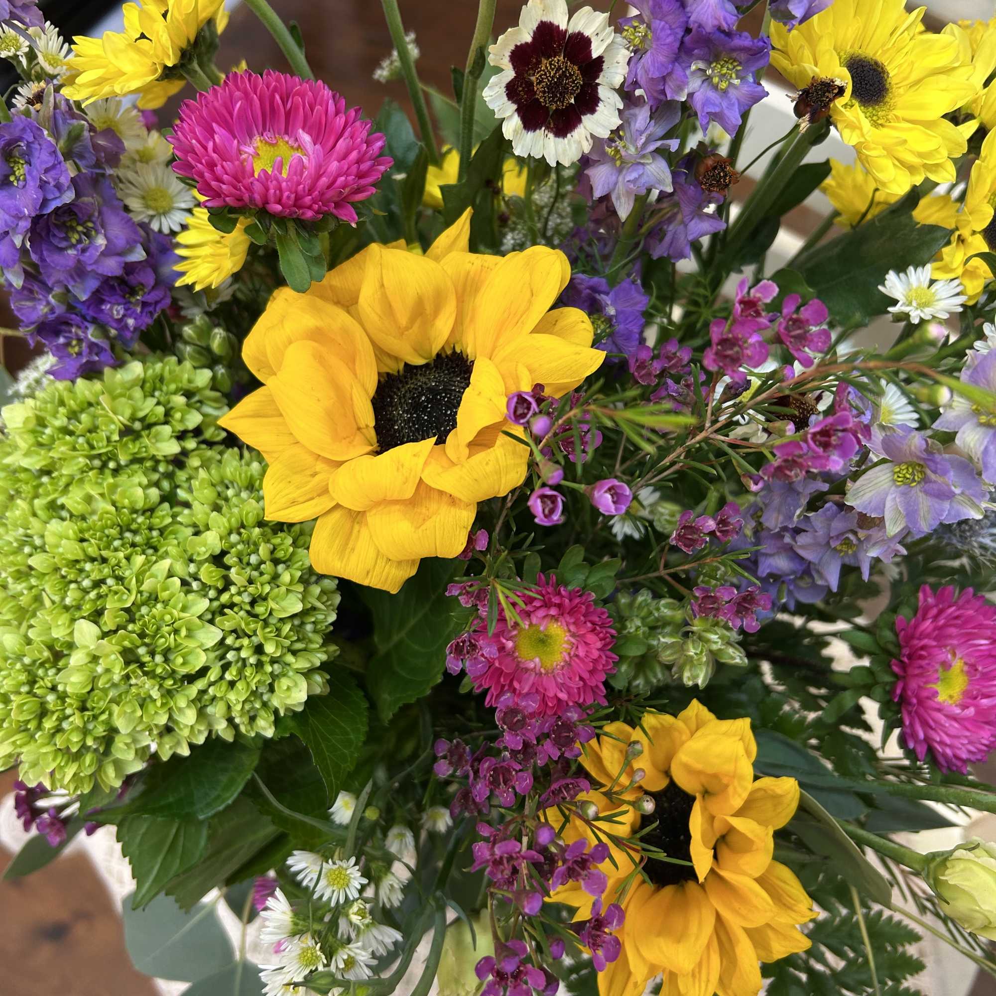 Mixed bouquet with yellow sunflowers, purple blooms, and pink flowers