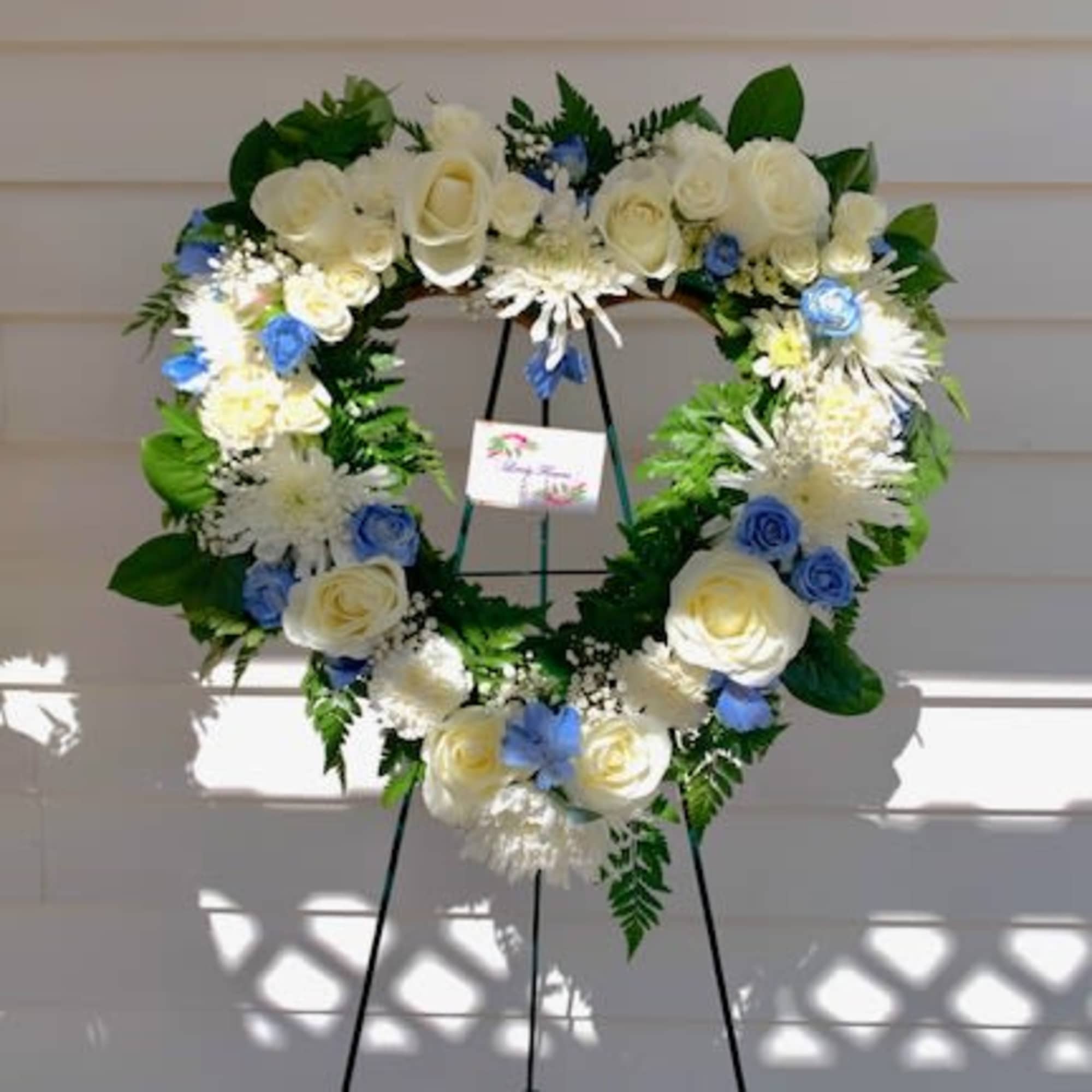 An all white tribute, this white cross funeral spray is pure and