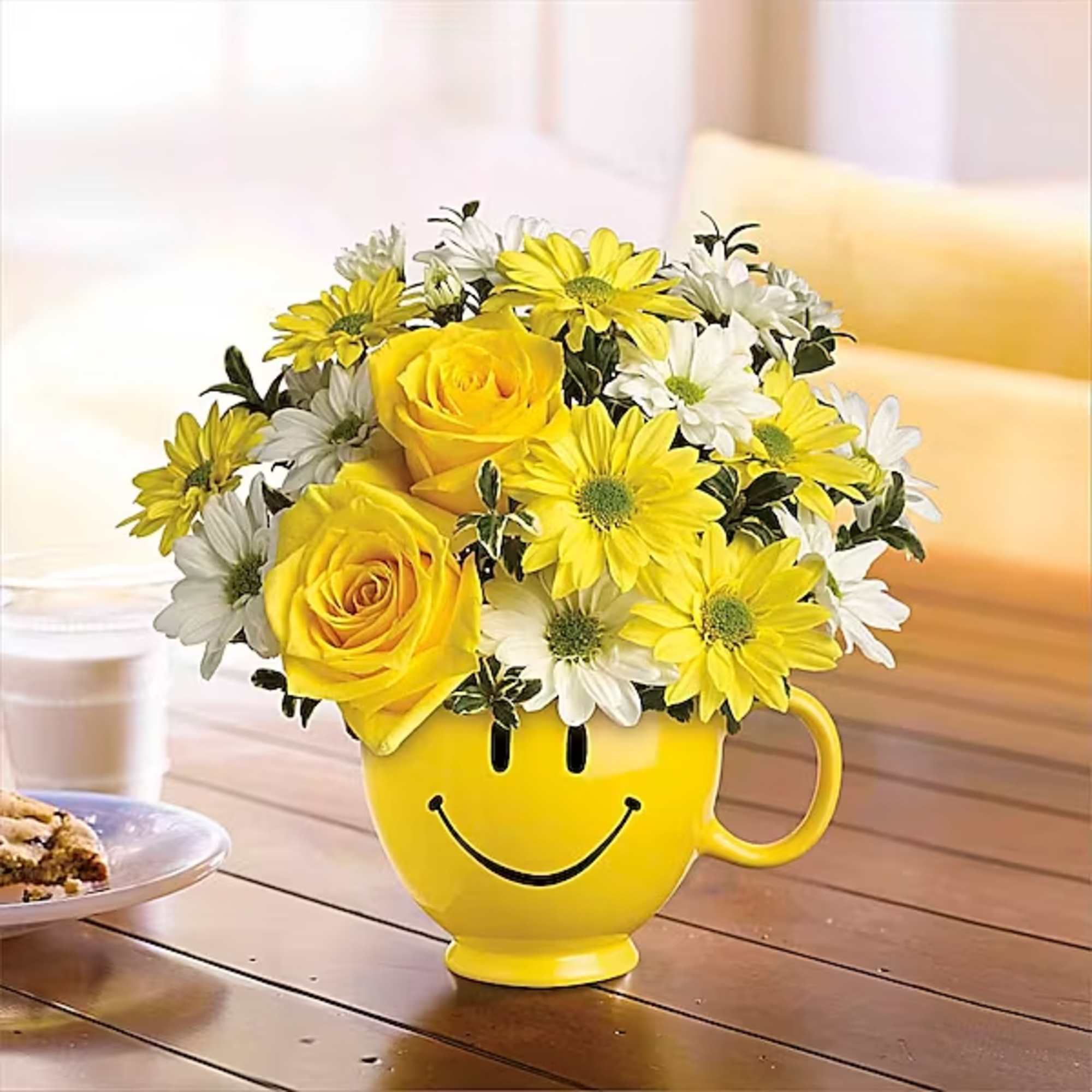 Yellow roses and daisies in a smiley-face mug