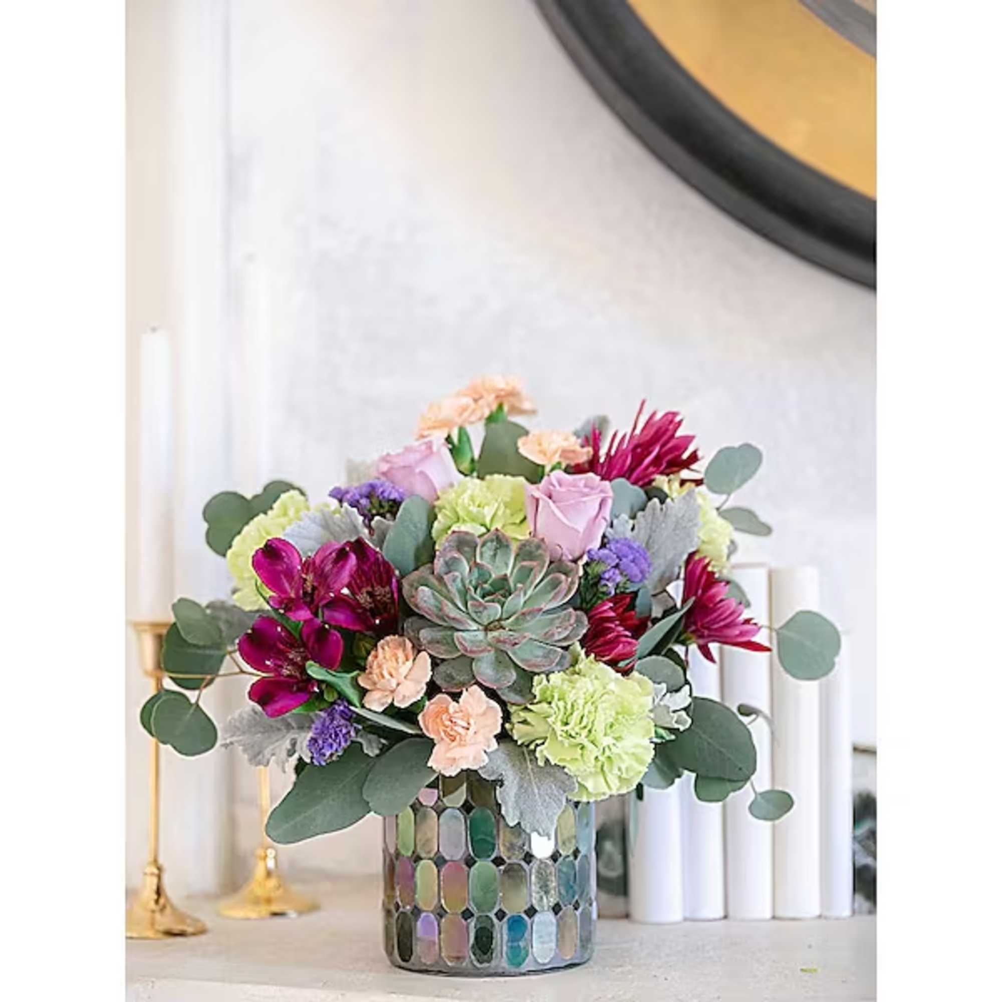 Mixed floral arrangement with succulents in a mosaic glass vase