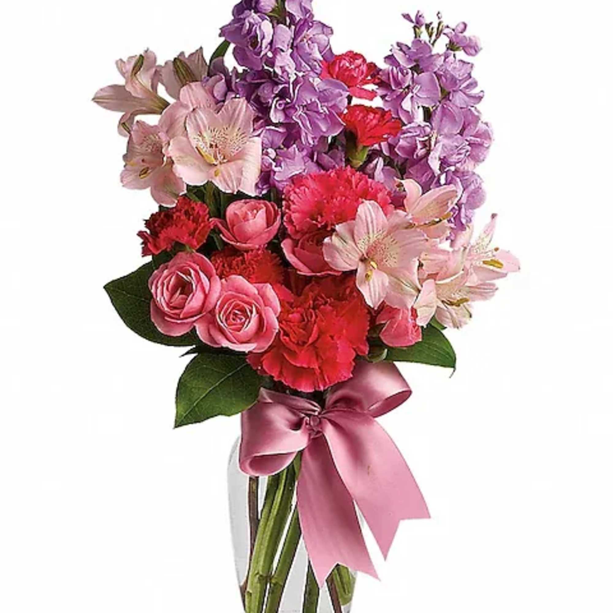 Pink and purple mixed bouquet in a clear glass vase with a satin ribbon