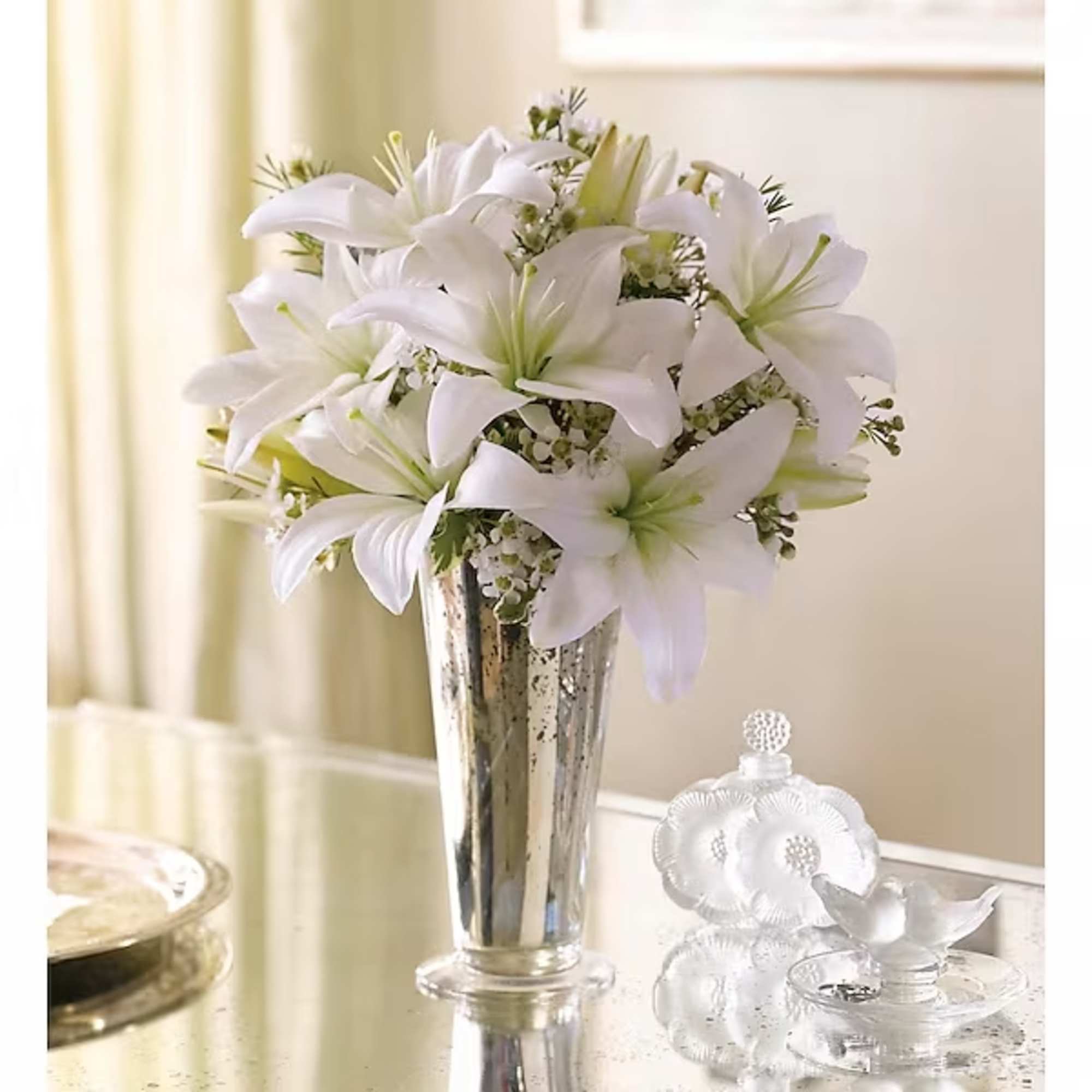 White lilies in a silver vase on a table