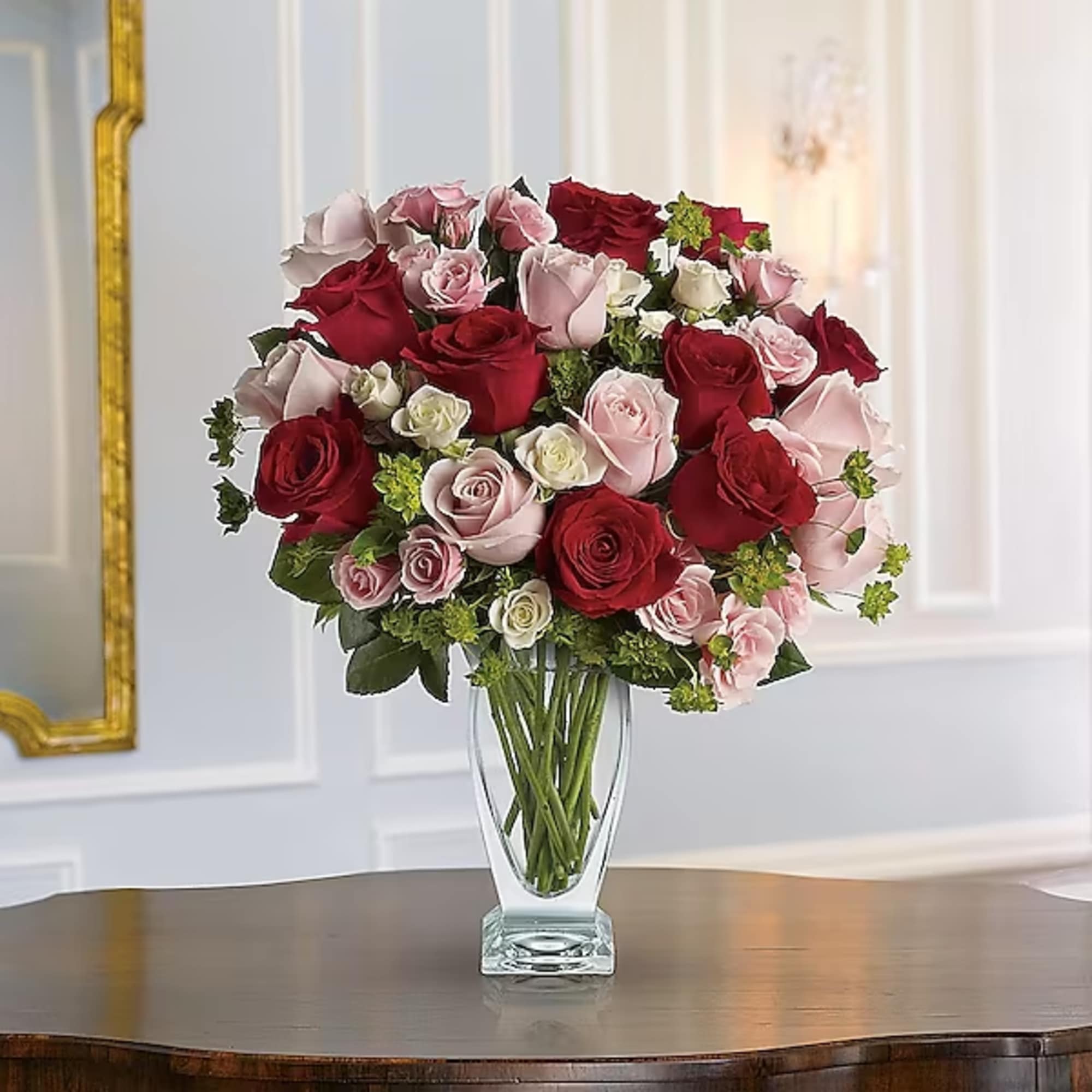 Bouquet of red and pink roses in a clear glass vase