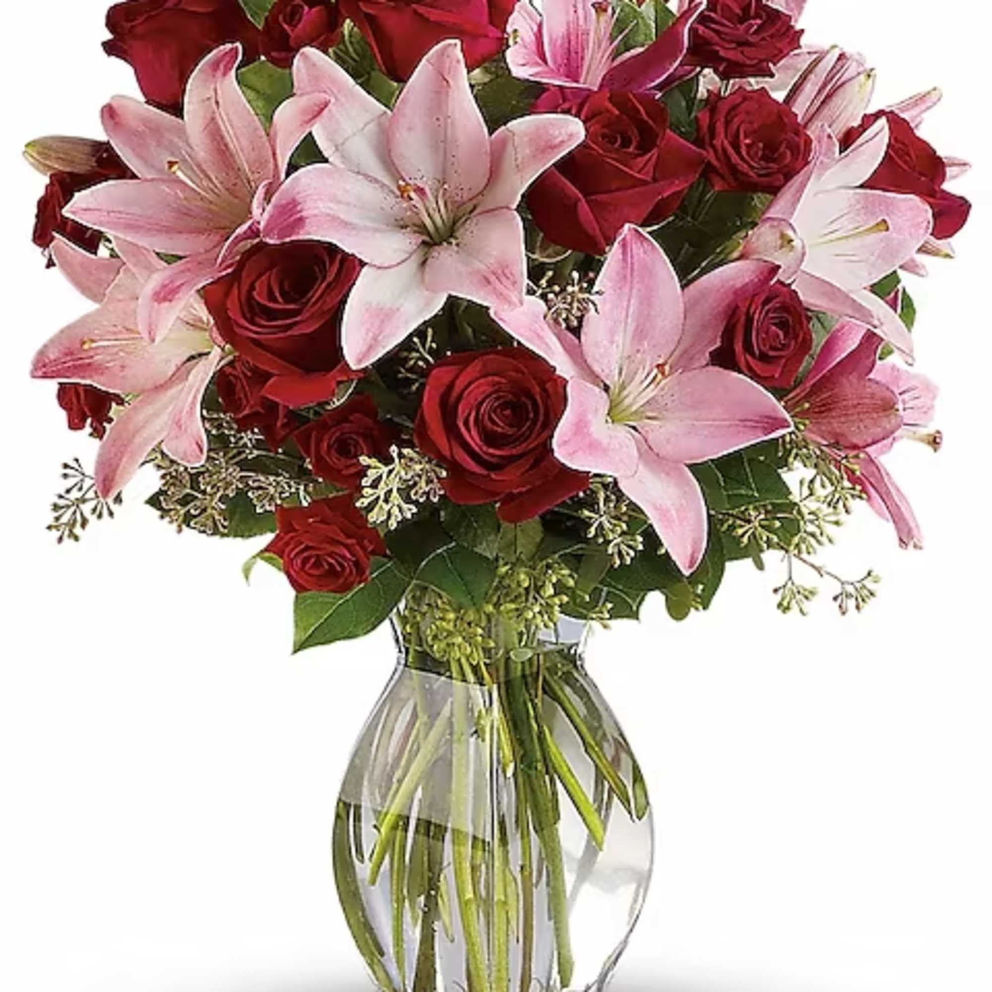 Red roses and pink lilies arranged in a clear glass vase