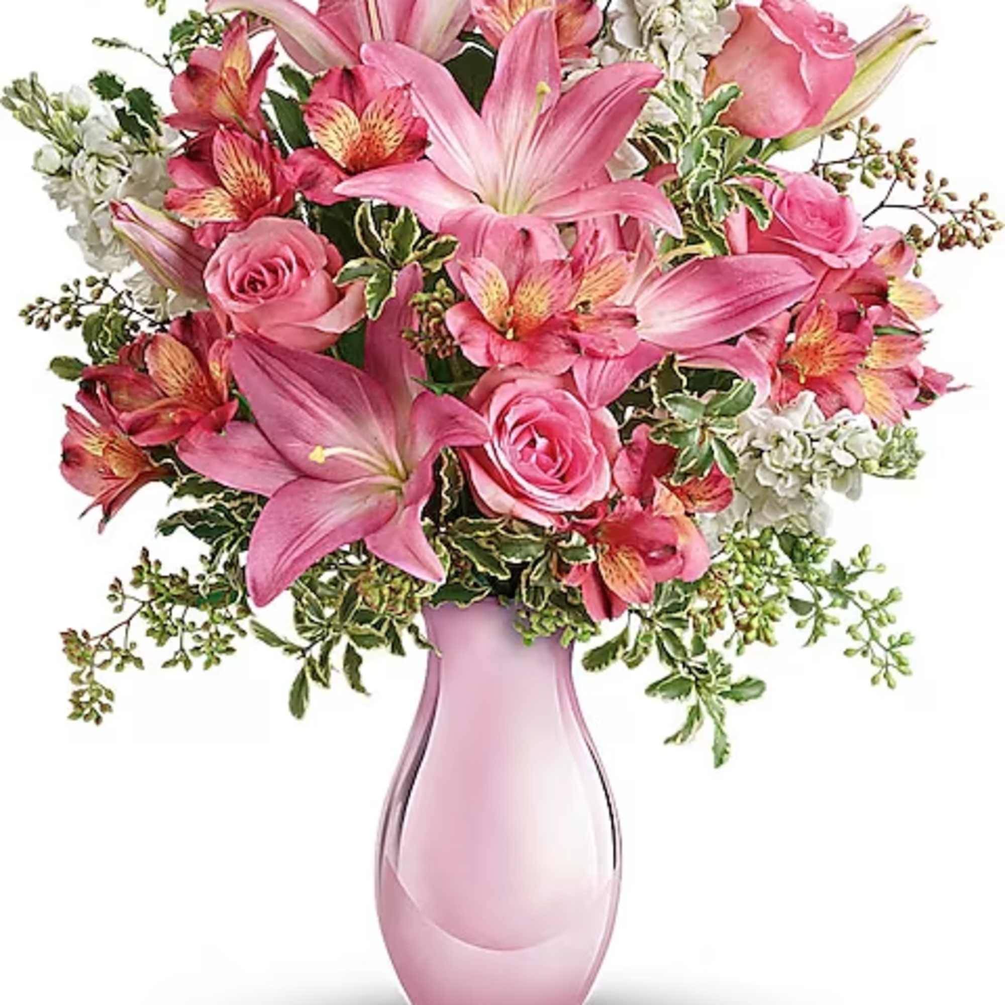 Pink lilies and roses arranged in a pink glass vase
