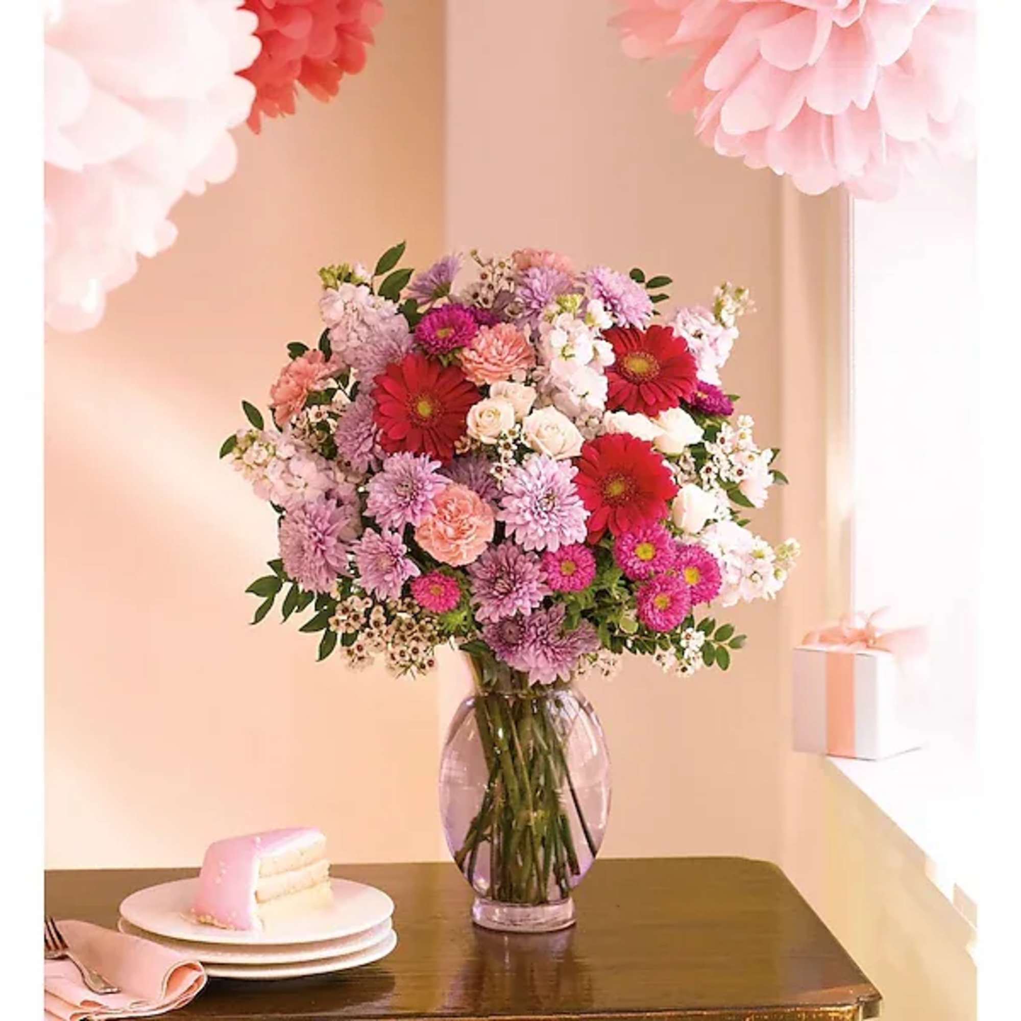 Mixed pink and red flower bouquet in a clear glass vase