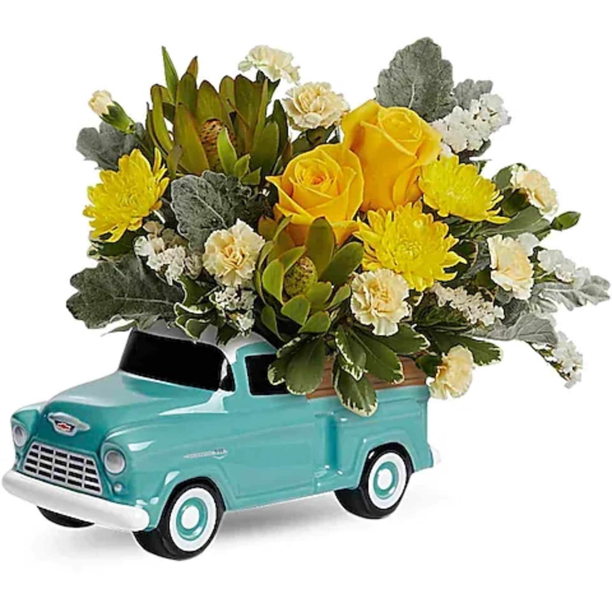 Yellow roses and chrysanthemums arranged in a turquoise truck planter