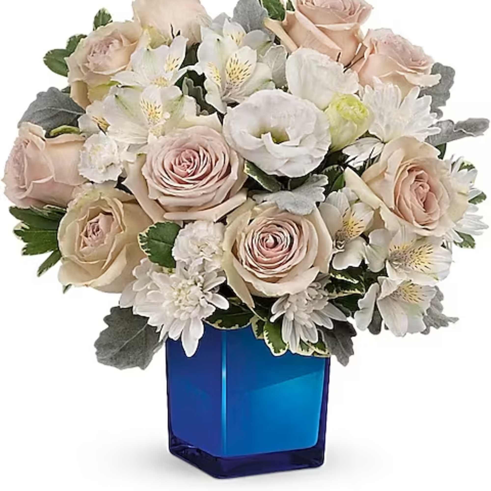 Blush roses and white flowers arranged in a blue glass vase