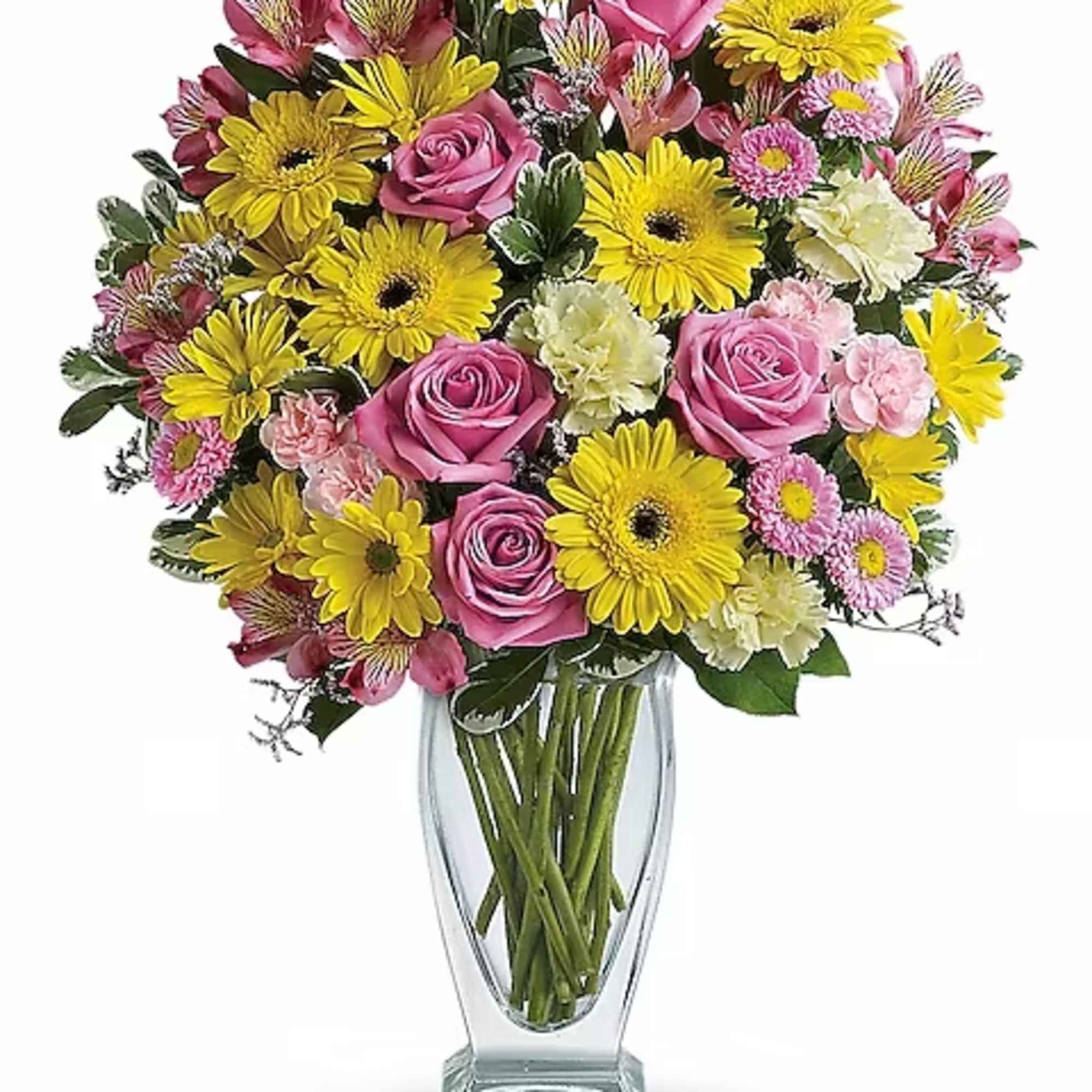 Bouquet of pink roses and yellow daisies in a clear glass vase