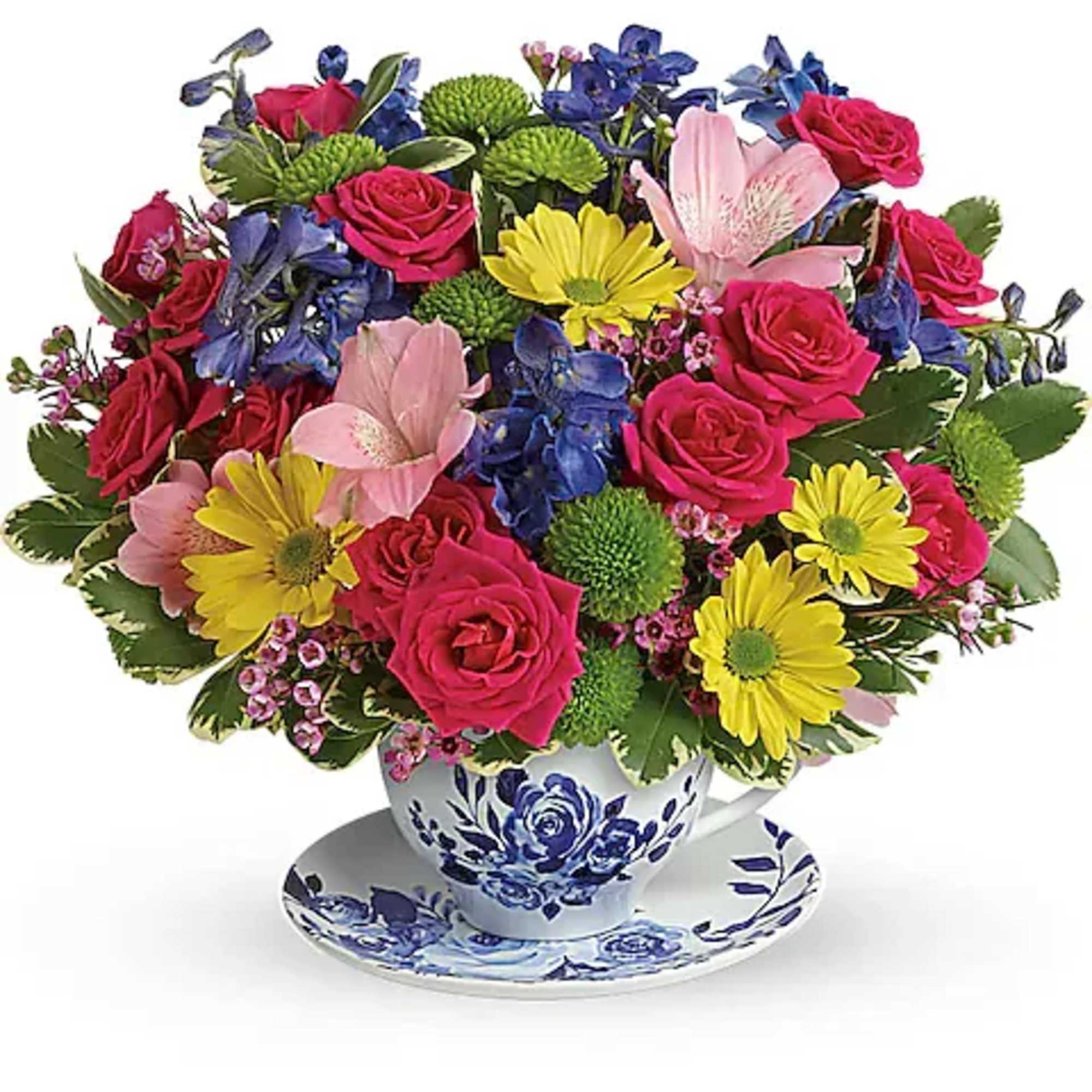 Colorful bouquet of roses, daisies, and blue flowers in a teacup vase