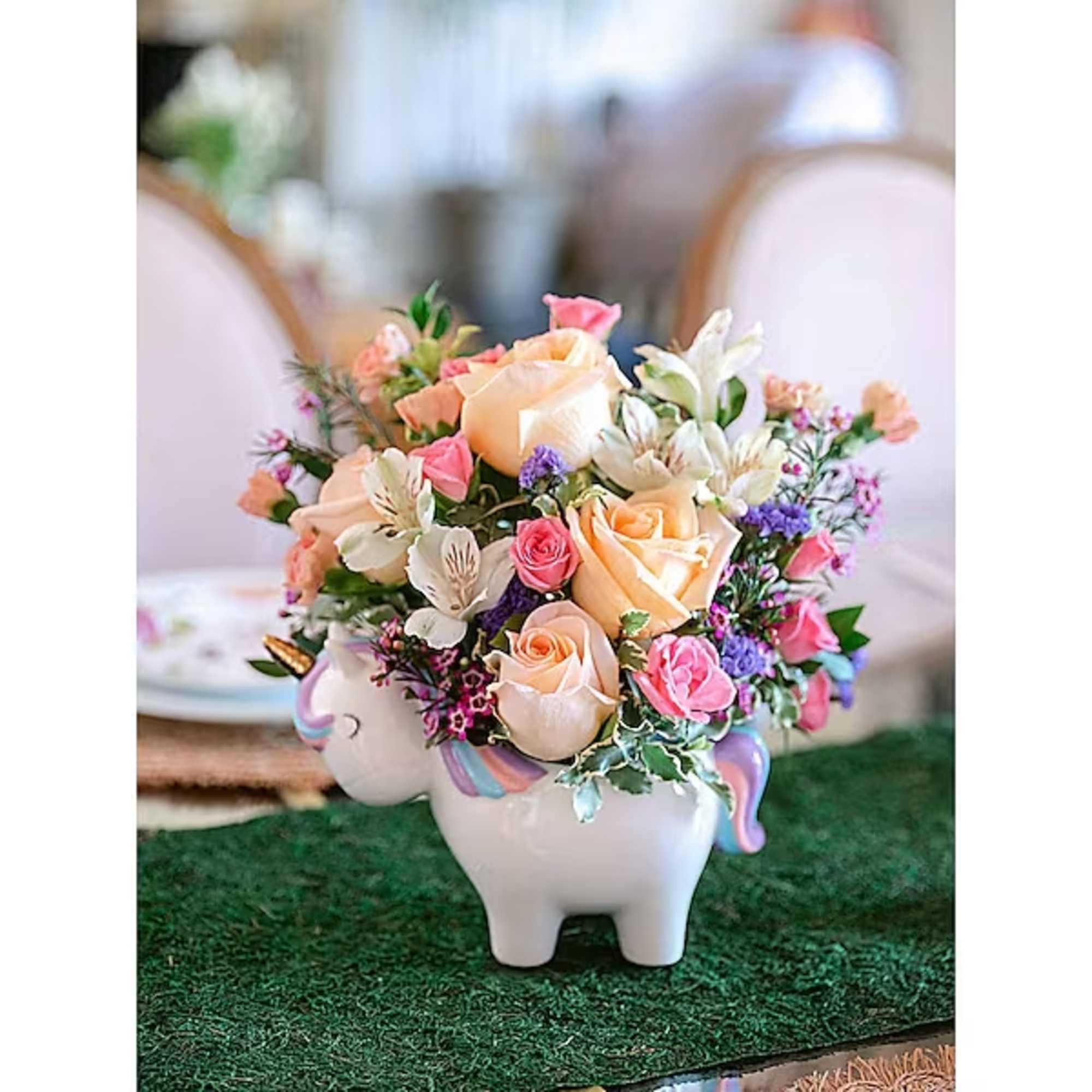 Bouquet of pastel roses and white flowers in a unicorn-shaped vase