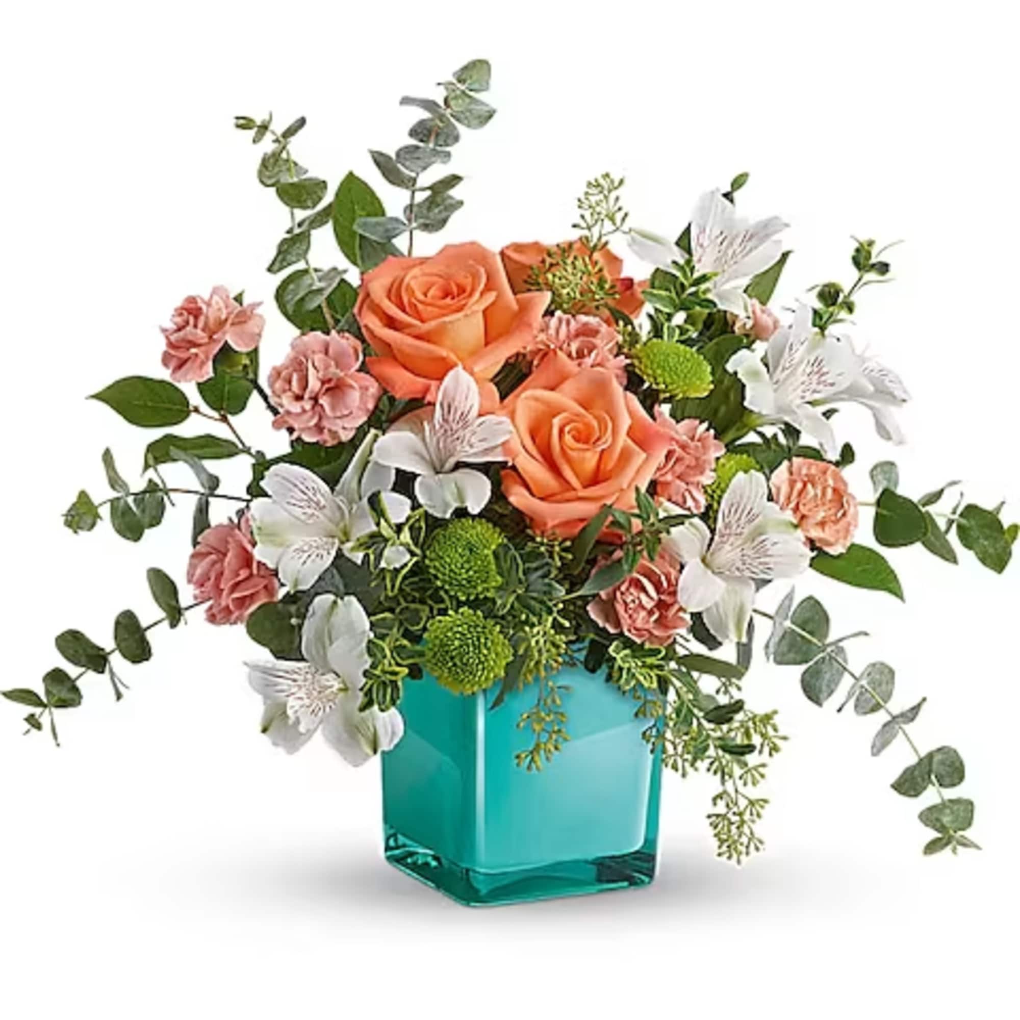 Peach roses and white flowers in a turquoise glass vase