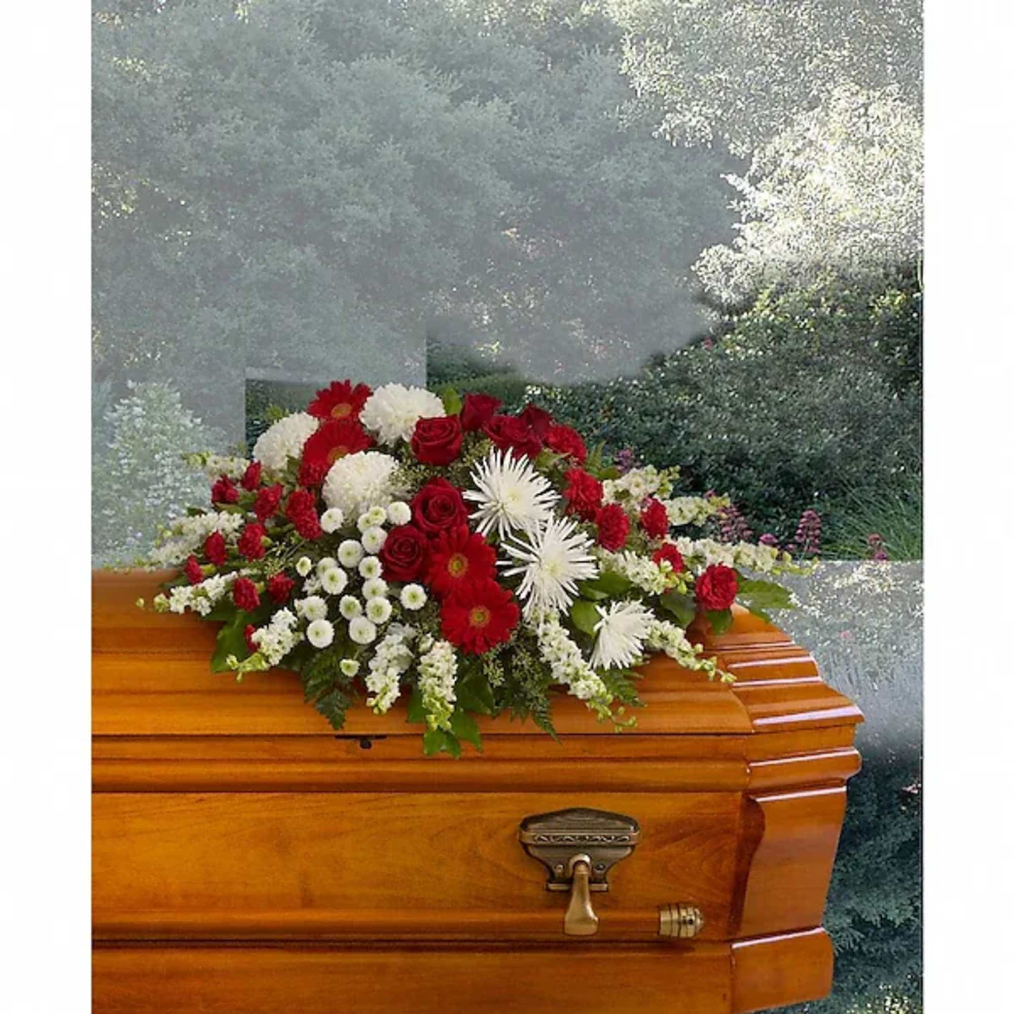 Red and white floral spray on a wooden casket