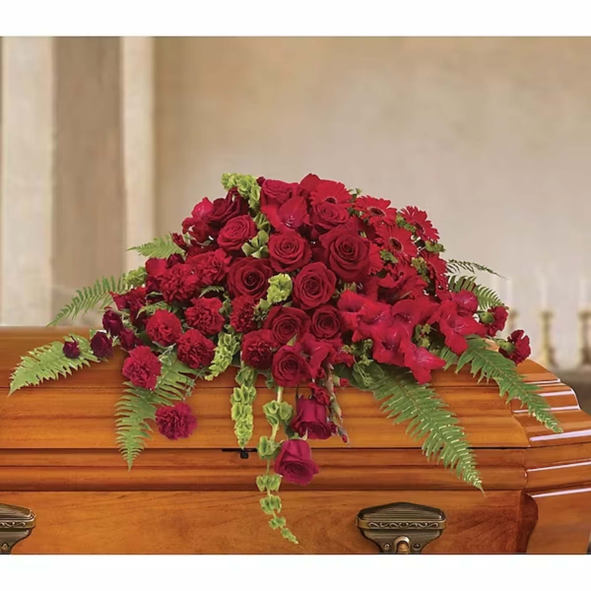 Red floral spray on a wooden casket