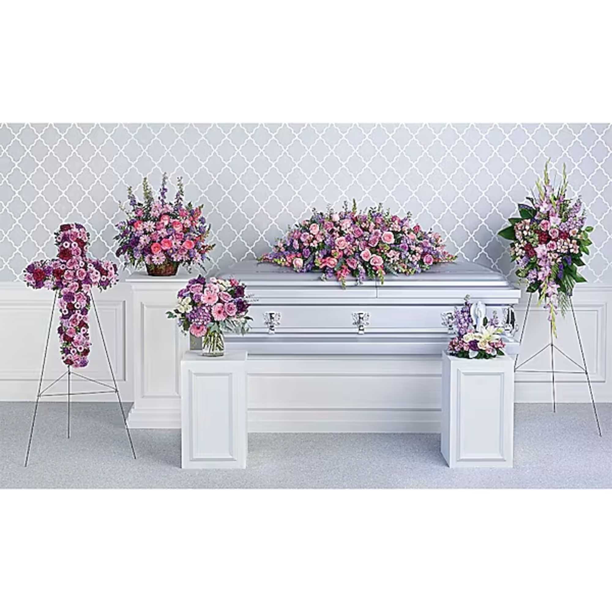 Floral casket spray with pink and purple flowers on a white casket