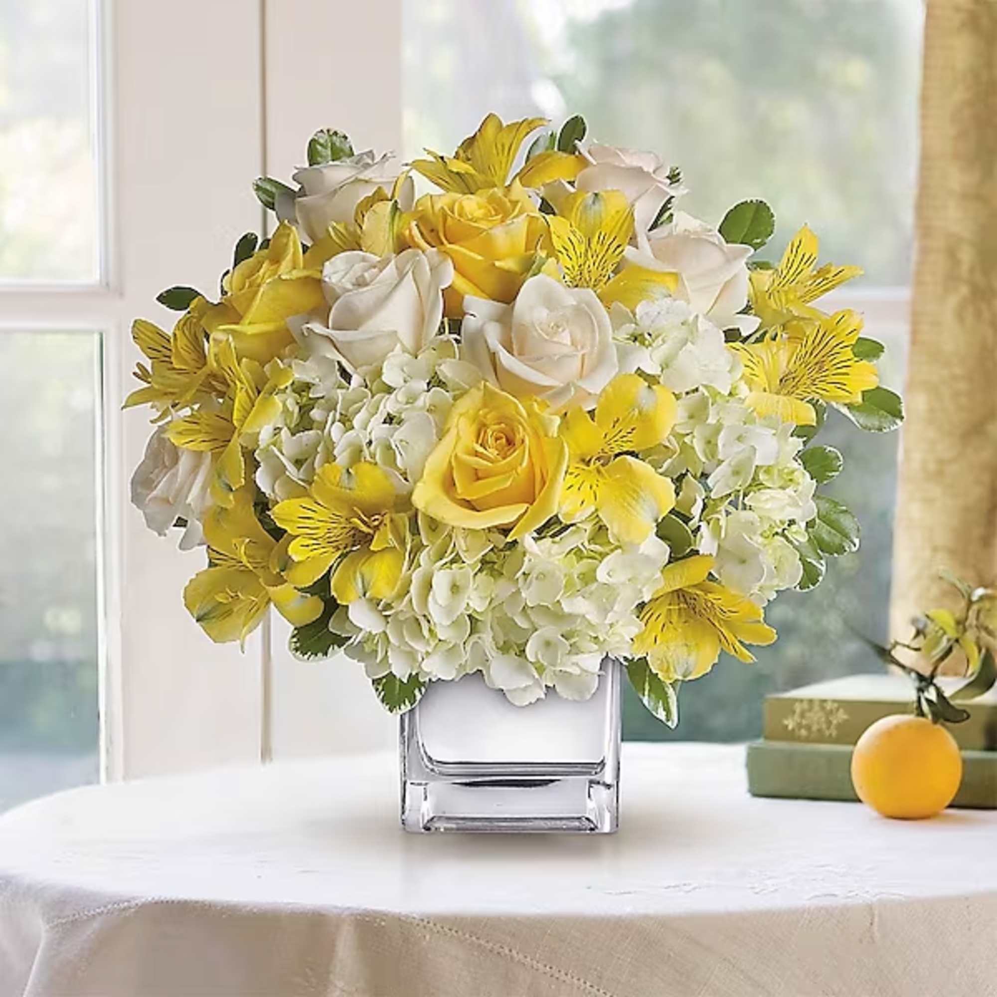Yellow and white bouquet in a clear square vase