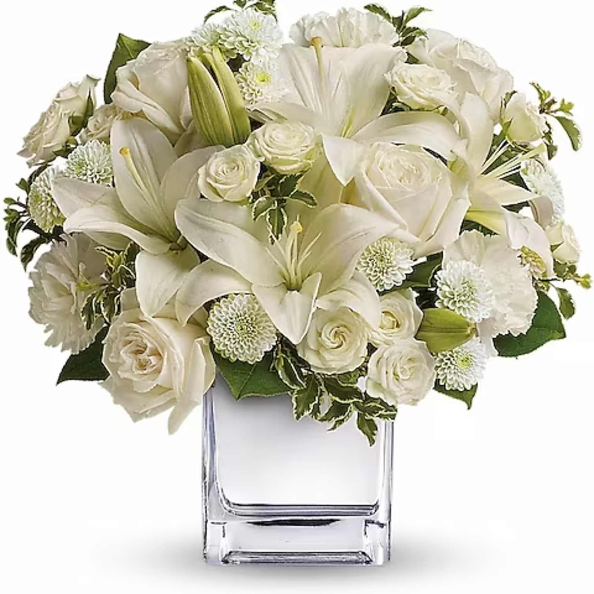 White lilies and roses arranged in a clear glass vase