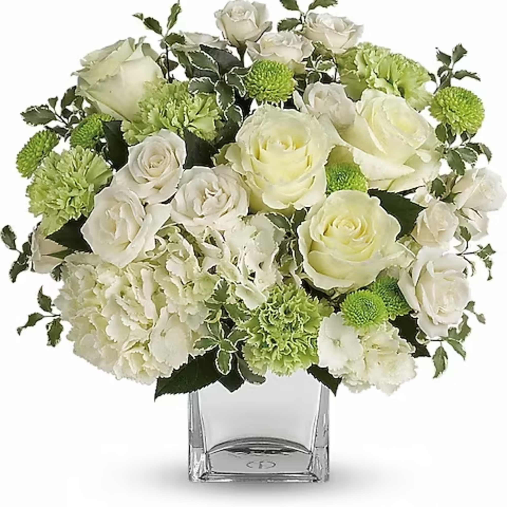 White roses and green carnations in a clear glass vase