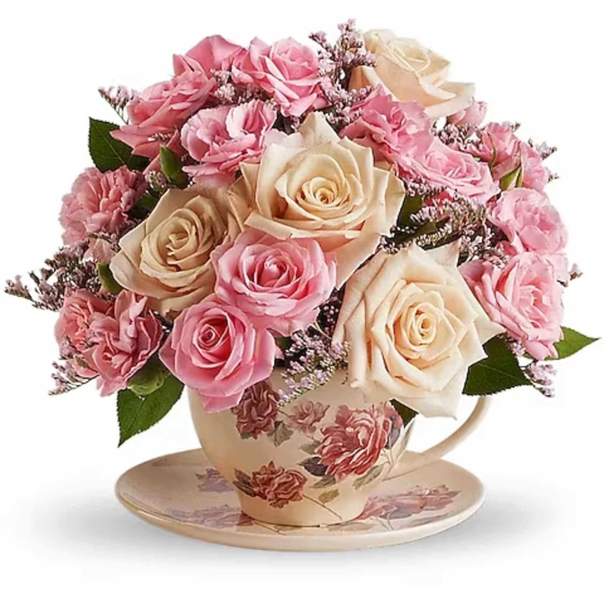 Pink and cream roses arranged in a floral teacup with saucer