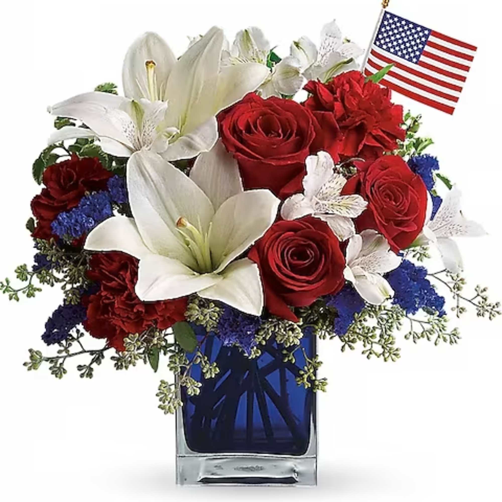 Red roses and white lilies in a blue glass vase with a small American flag