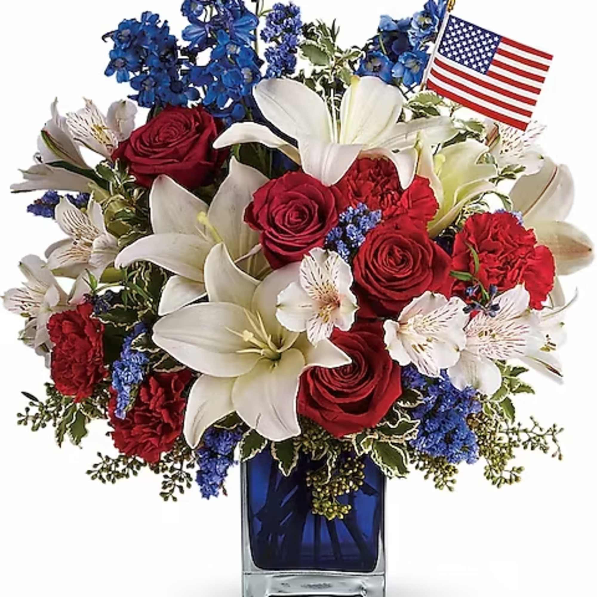 Red roses and white lilies in a blue vase with a small American flag