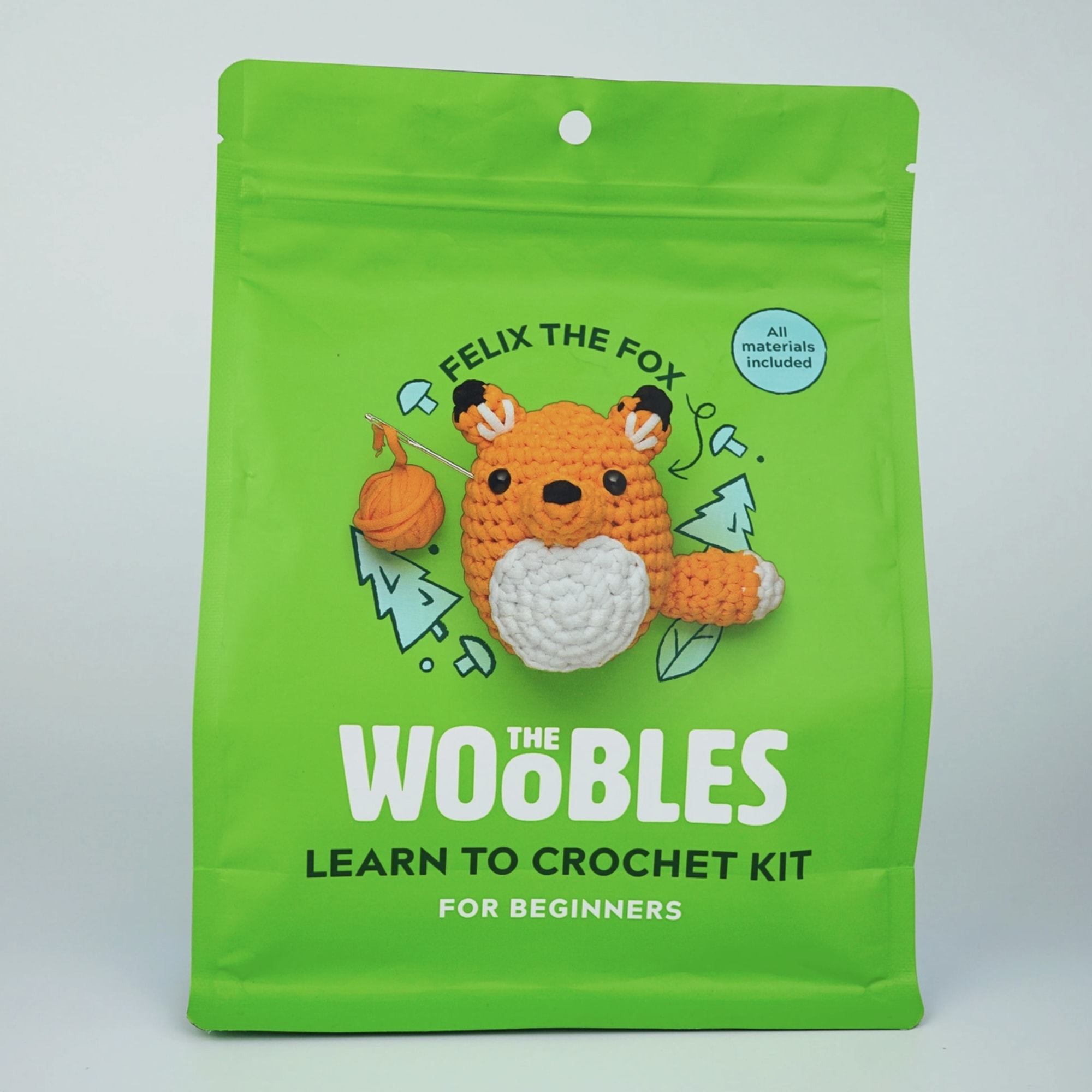 Green package for a fox crochet kit with a small crocheted fox on the front
