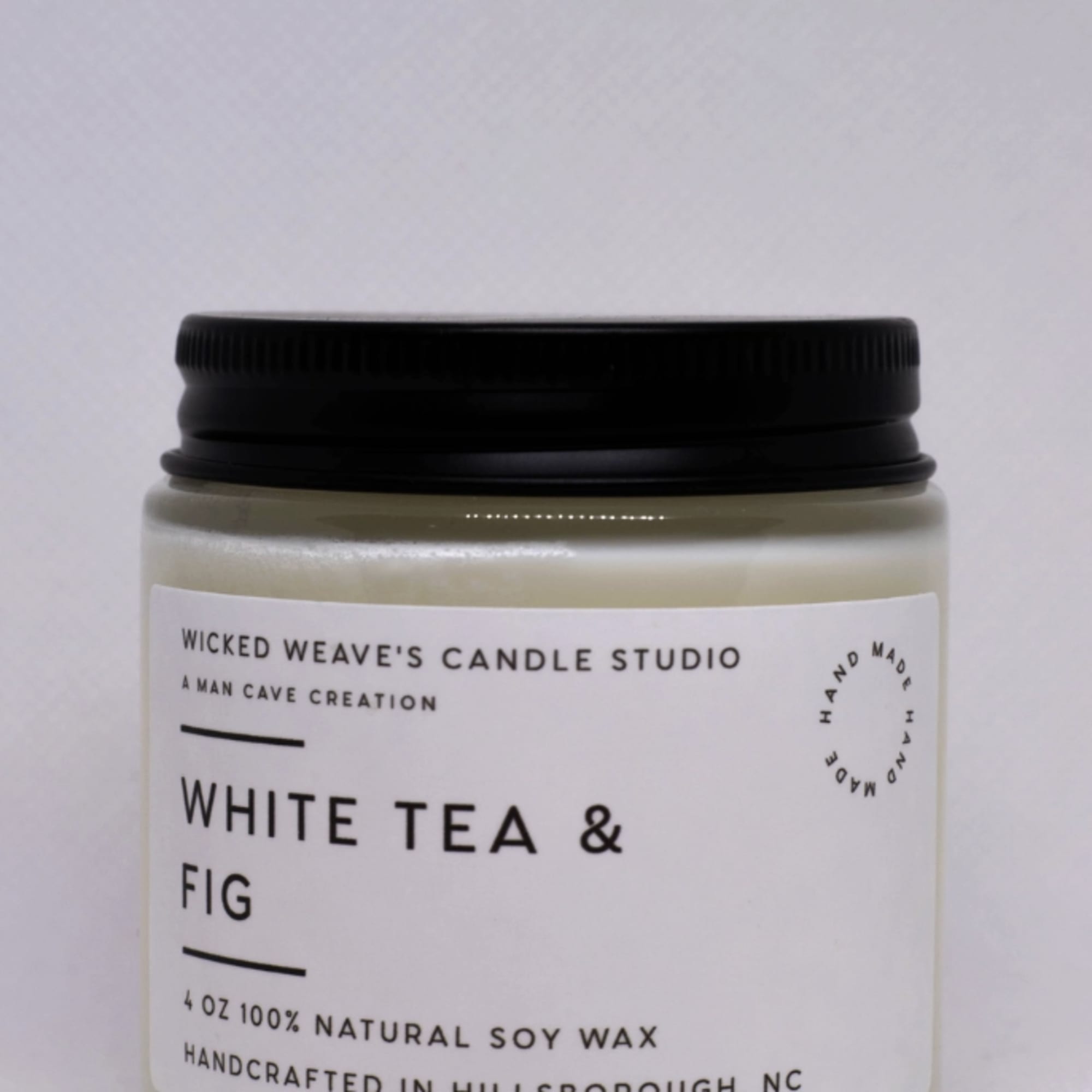 Jar candle with black lid labeled White Tea & Fig