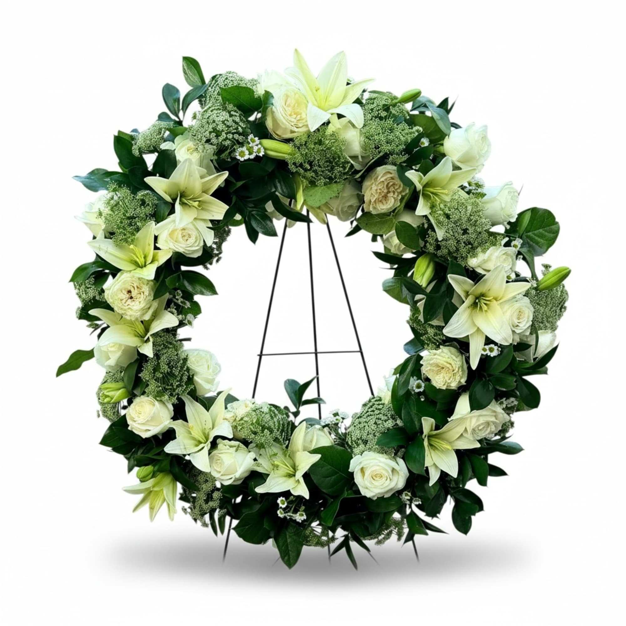 An elegant funeral wreath featuring white lilies, white roses, Queen Anne's lace