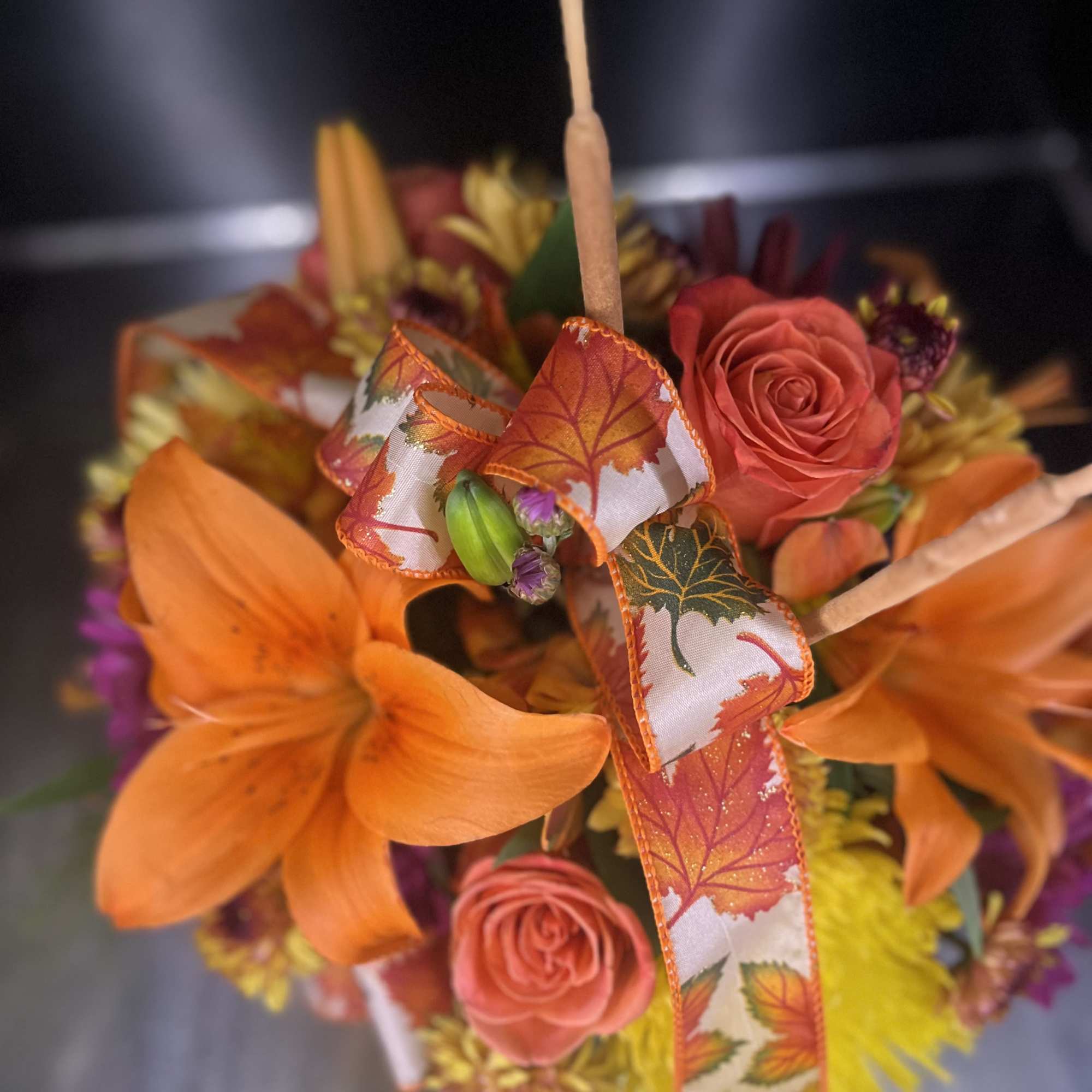 Orange lilies and pink roses with an autumn ribbon bow