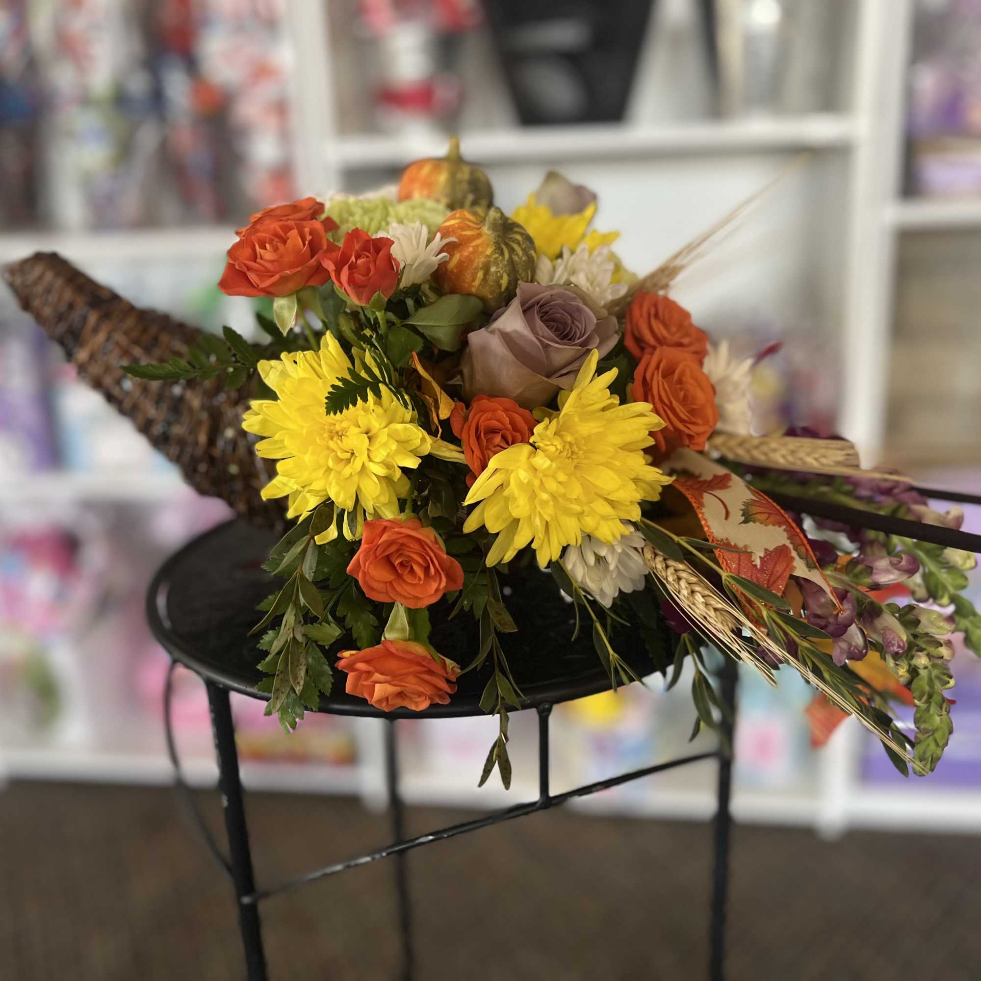Bouquet of orange and yellow flowers with decorative gourds
