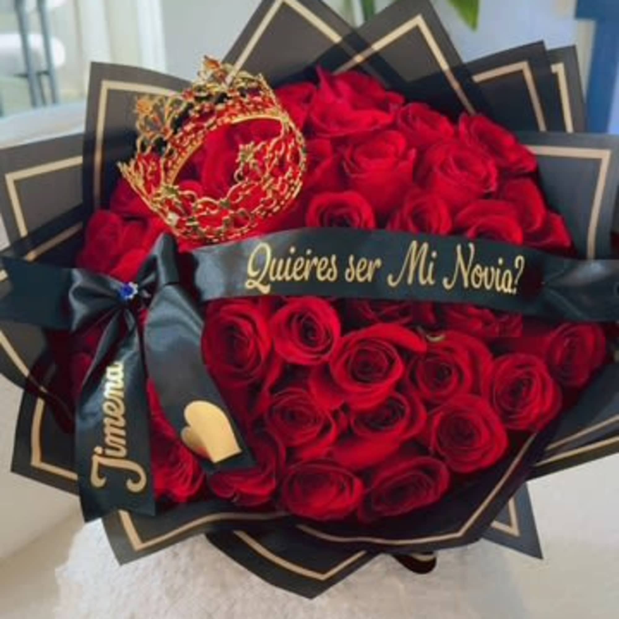 Bouquet of red roses with a black ribbon and gold crown decoration