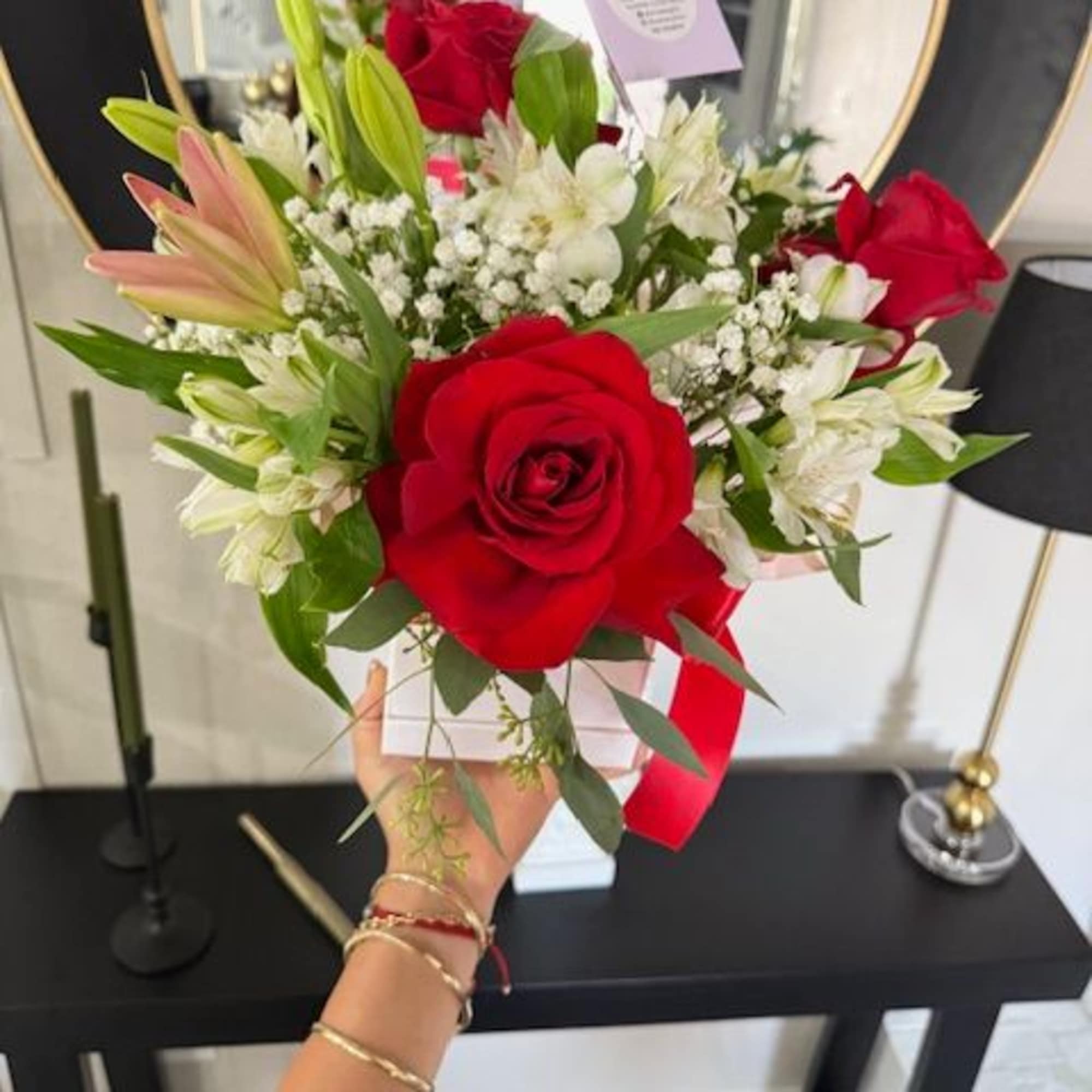 Bouquet of red roses and white lilies with baby's breath in a white box