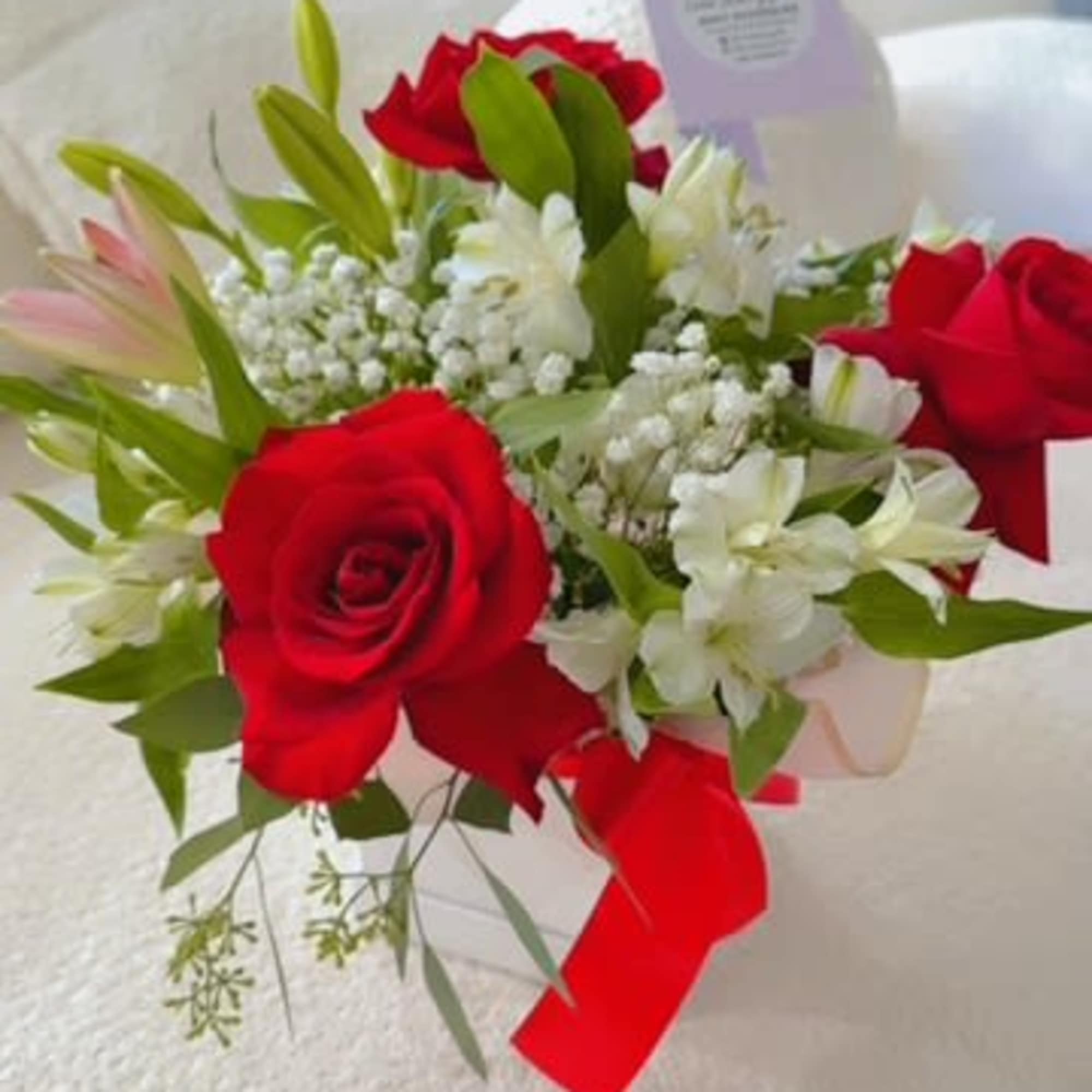 Bouquet of red roses and white lilies with a red ribbon