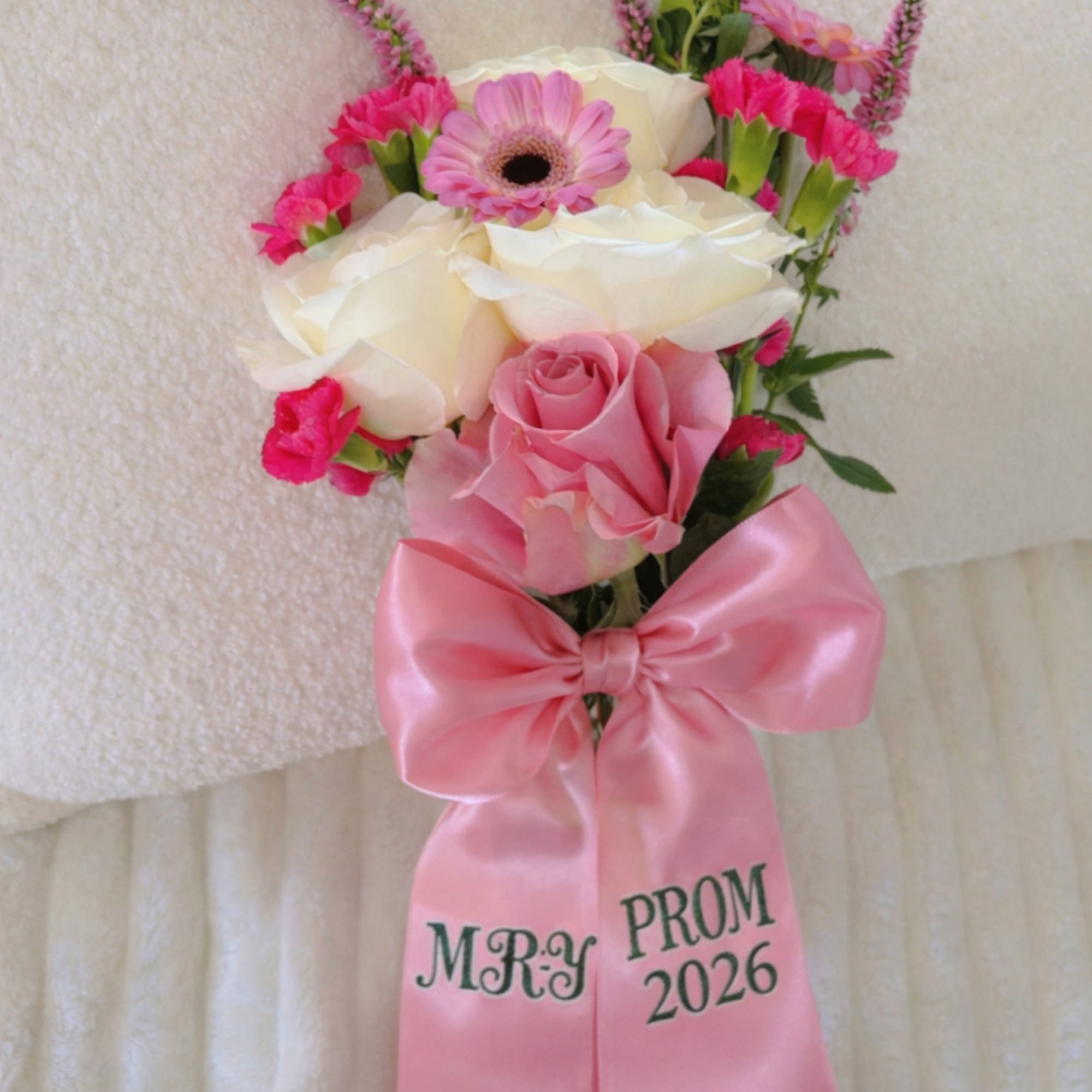 Pink and white prom corsage with roses, gerbera daisy, and a satin bow