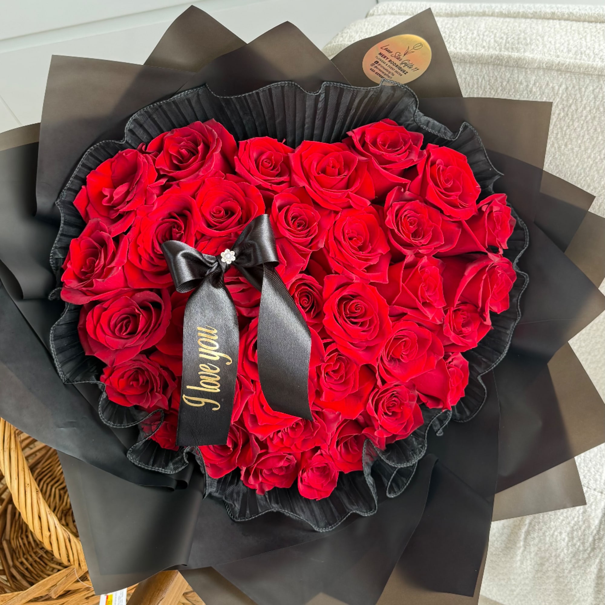 Bouquet of red roses wrapped in black paper with a black ribbon
