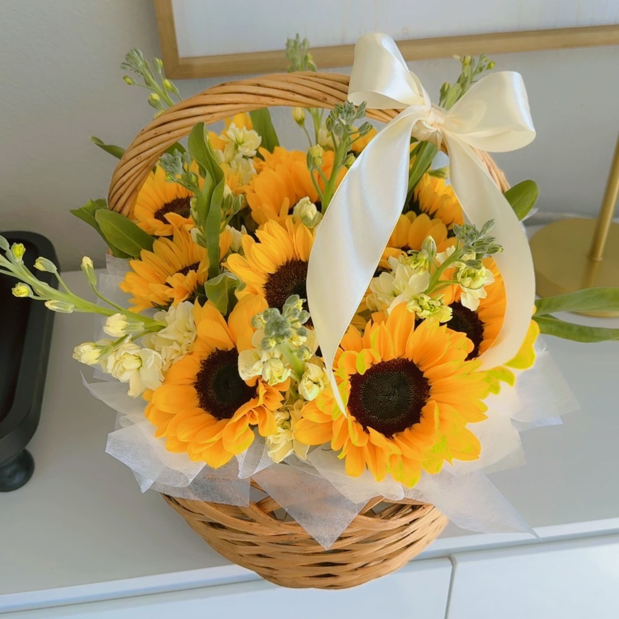 Basket of sunflowers with a white ribbon bow