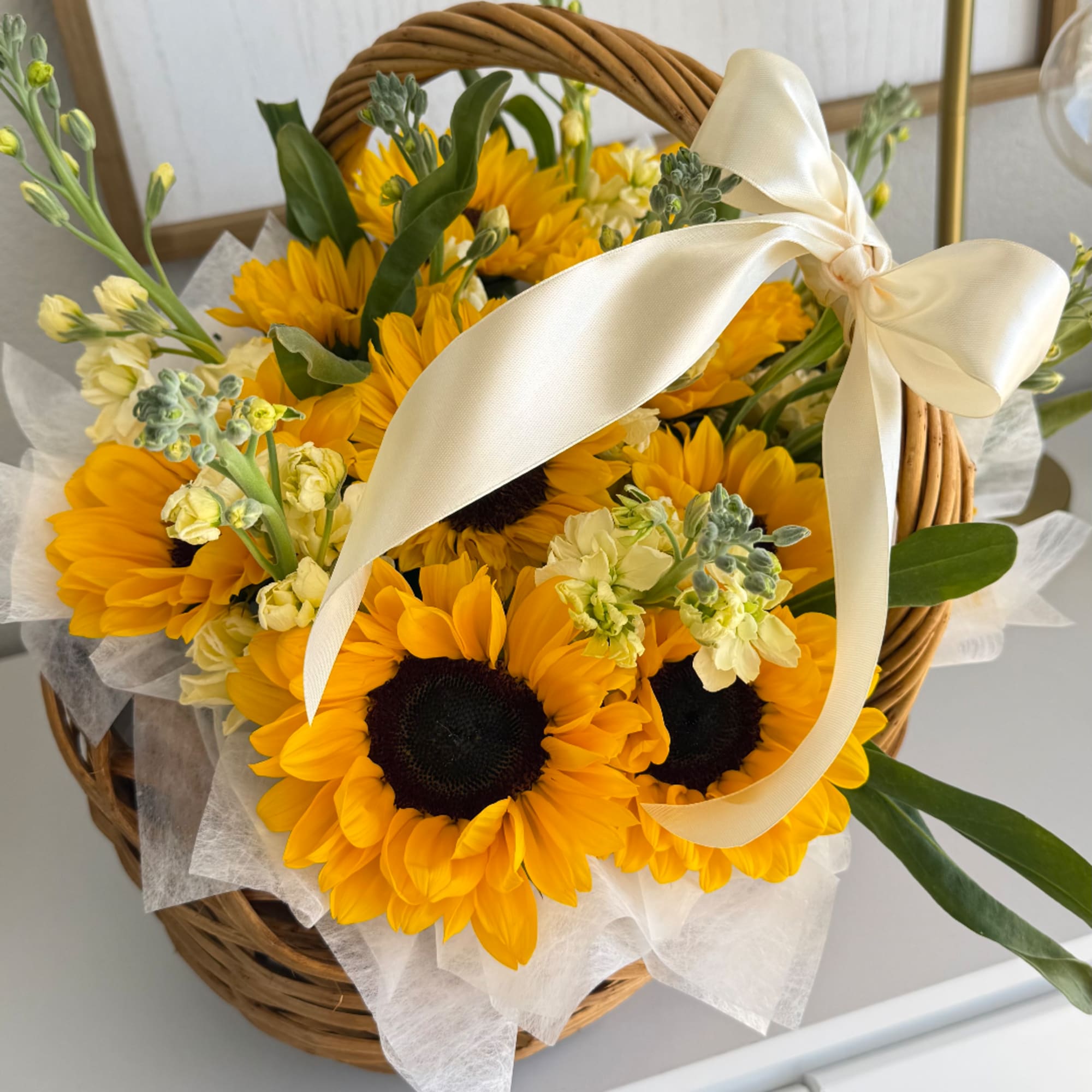 Basket of sunflowers with a cream ribbon bow