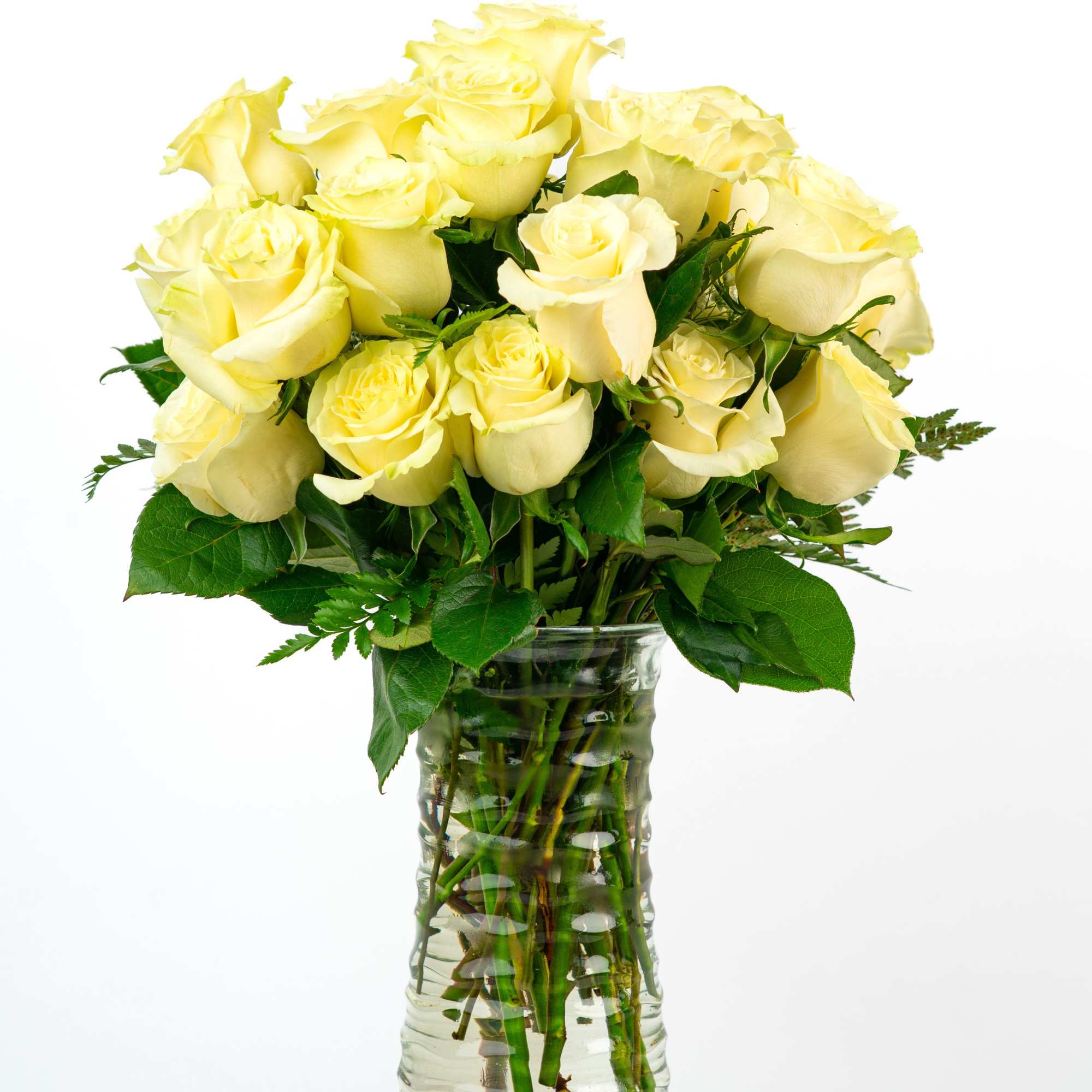 Tall clear vase filled with long-stemmed pale yellow roses