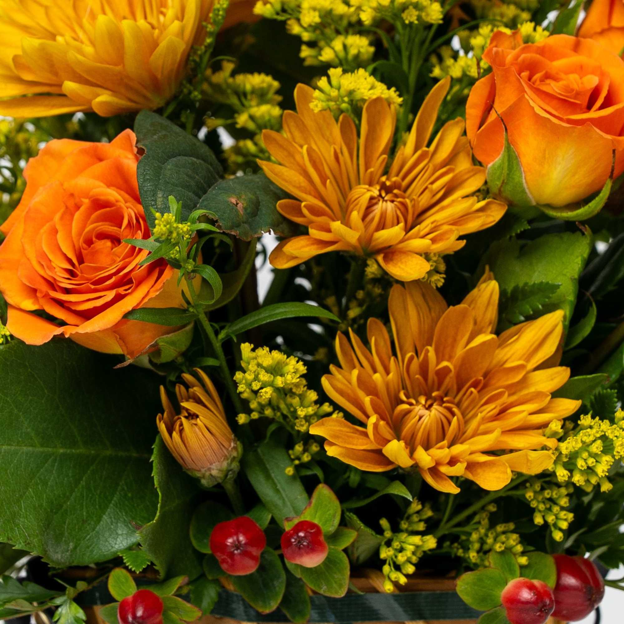 Orange roses and yellow chrysanthemums in a woven basket