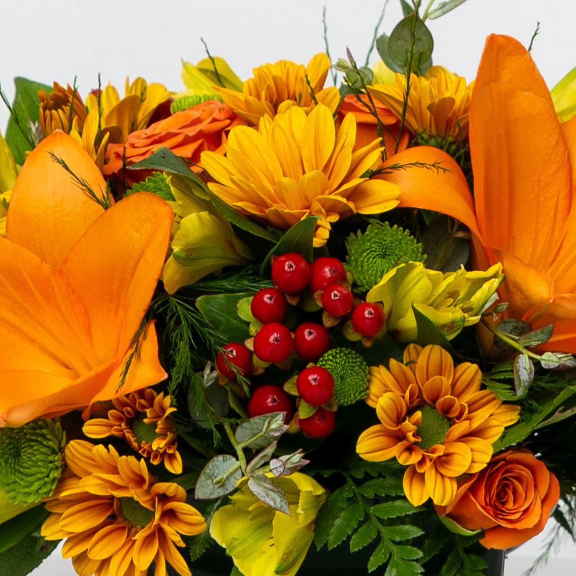 Orange and yellow bouquet with daisies, roses, and red berries