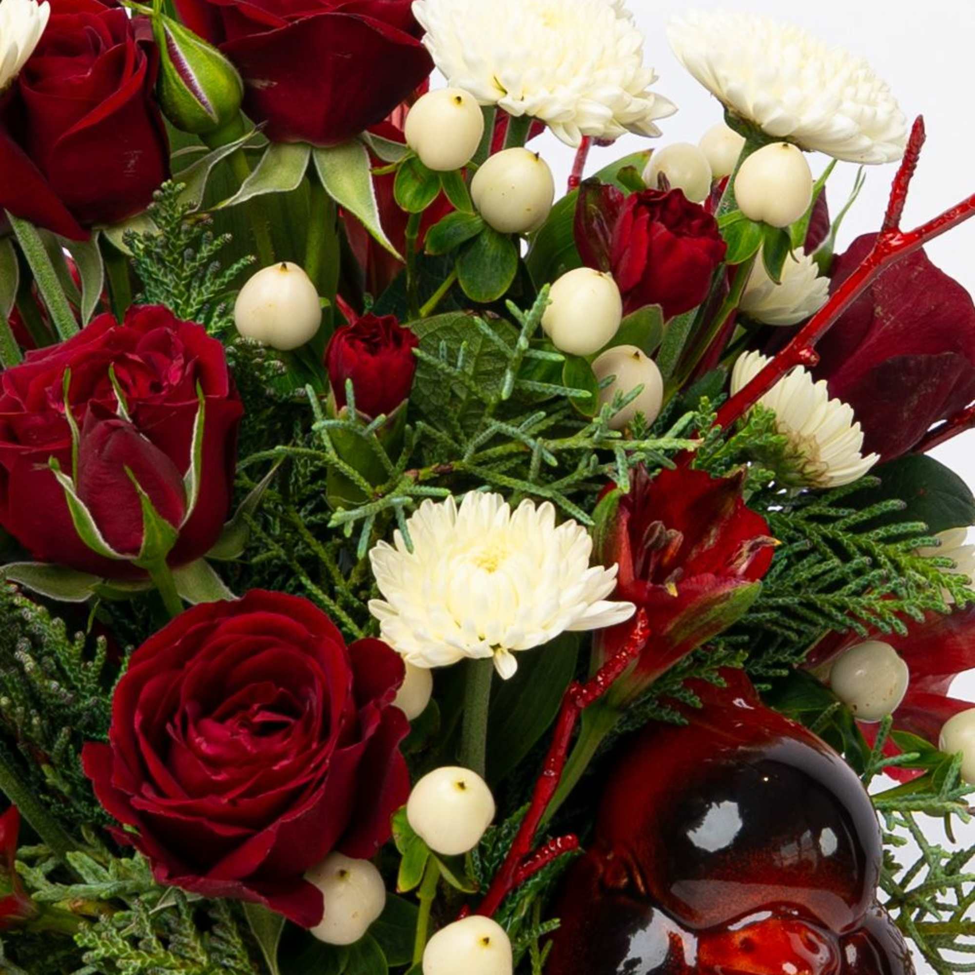 Red roses and white chrysanthemums with berries in a glass vase