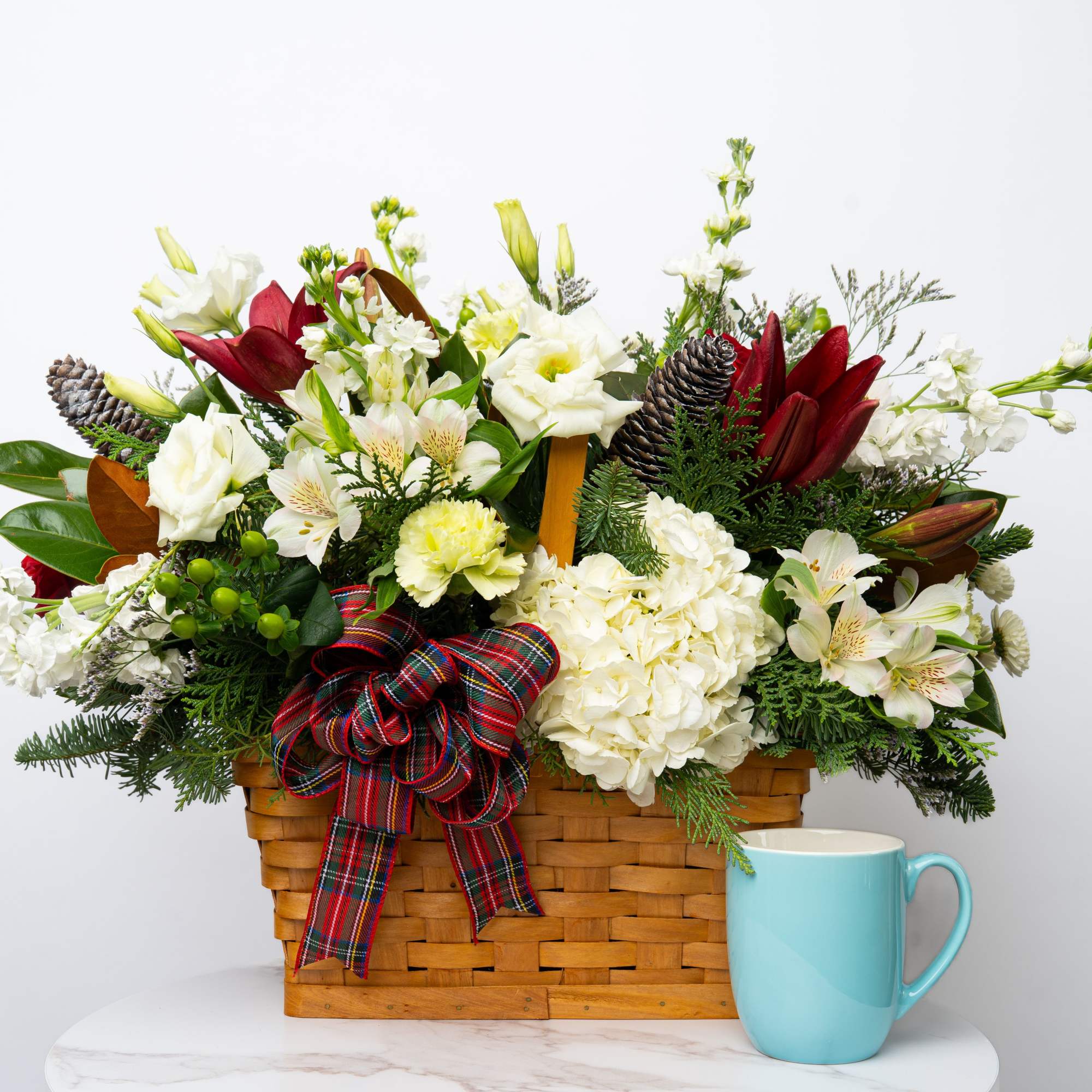 Holiday flower basket with white and red blooms in a woven basket