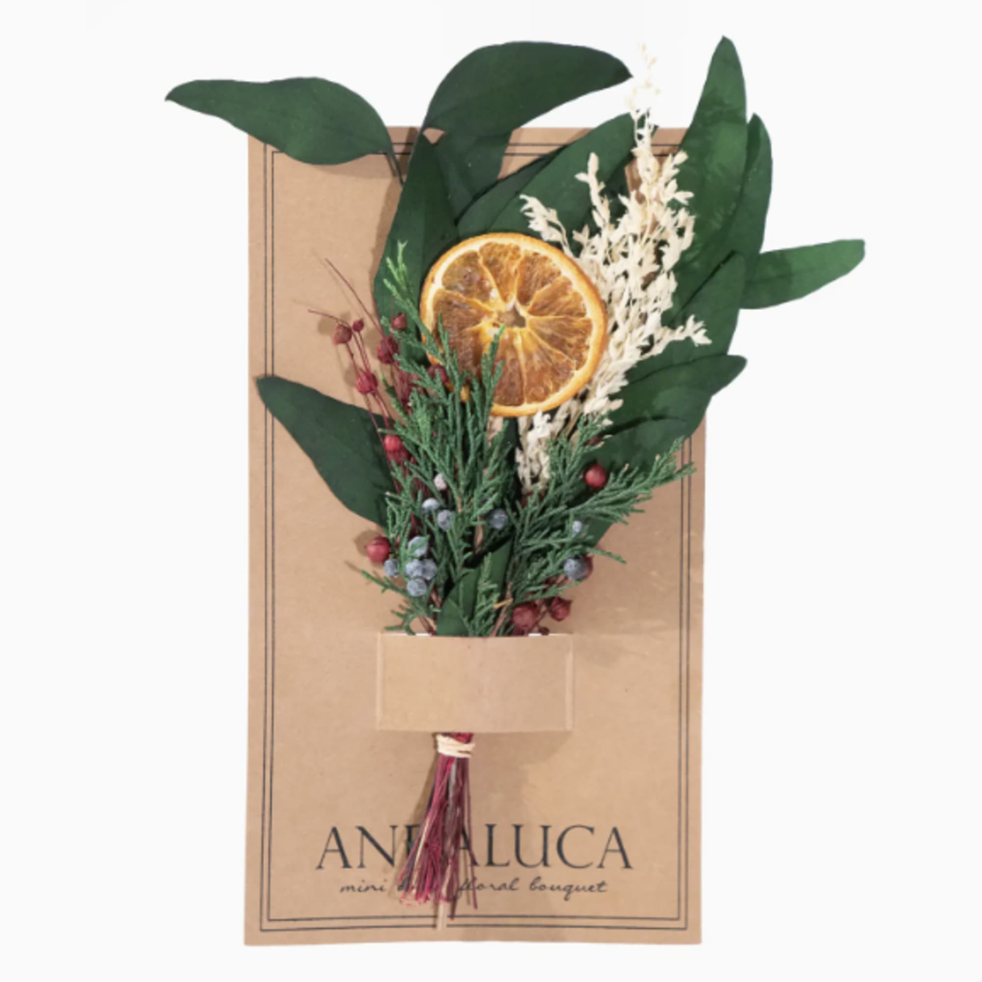 Dried bouquet with an orange slice and greenery on a kraft card