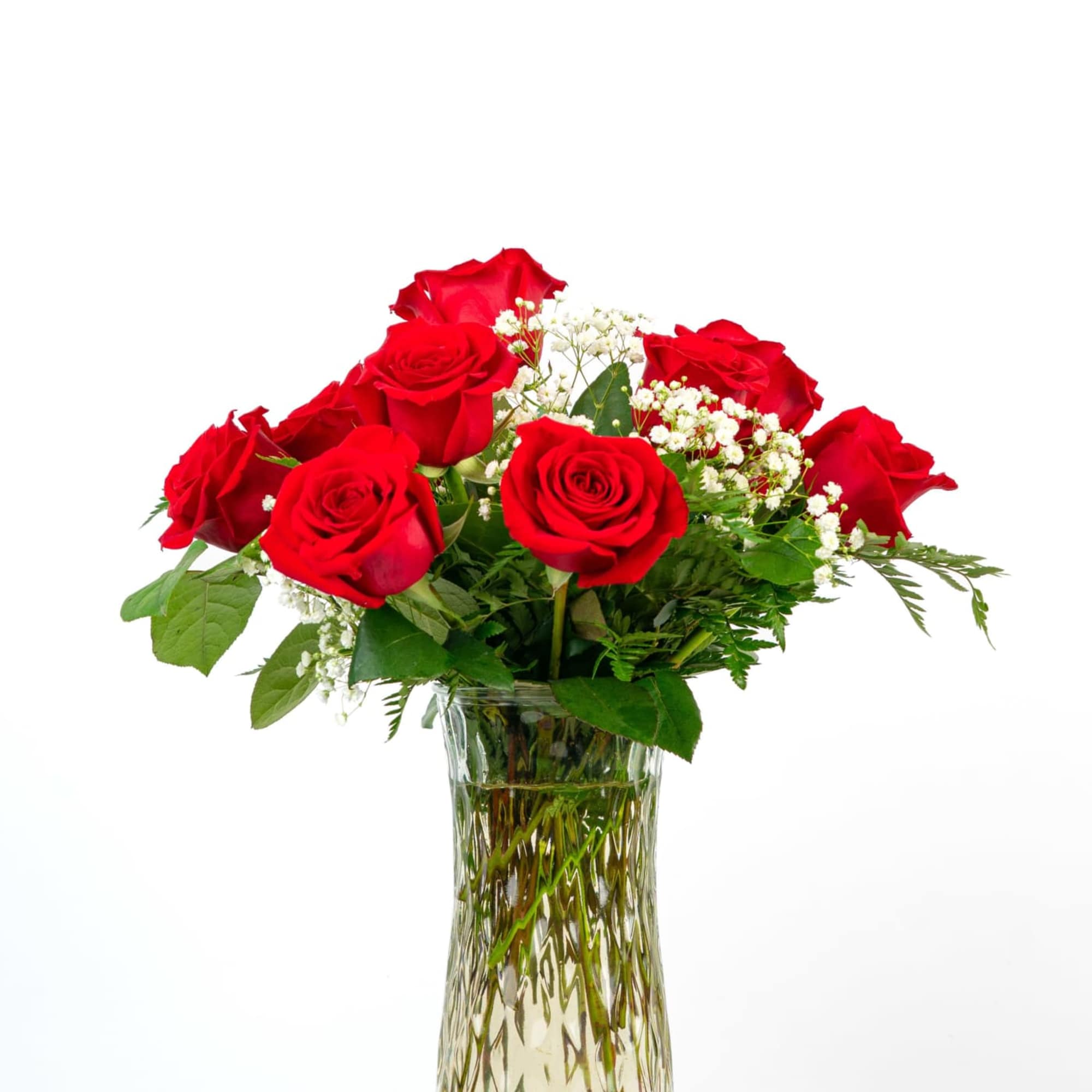 Red roses arranged in a clear glass vase with baby's breath
