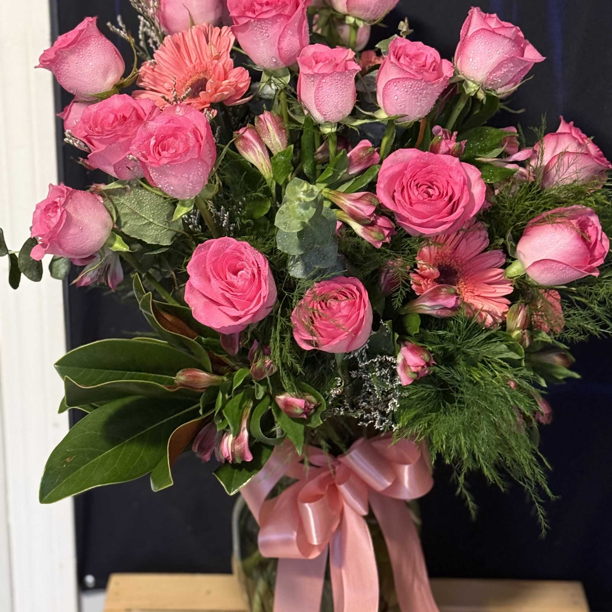 Pink rose bouquet with gerbera daisies in a glass vase