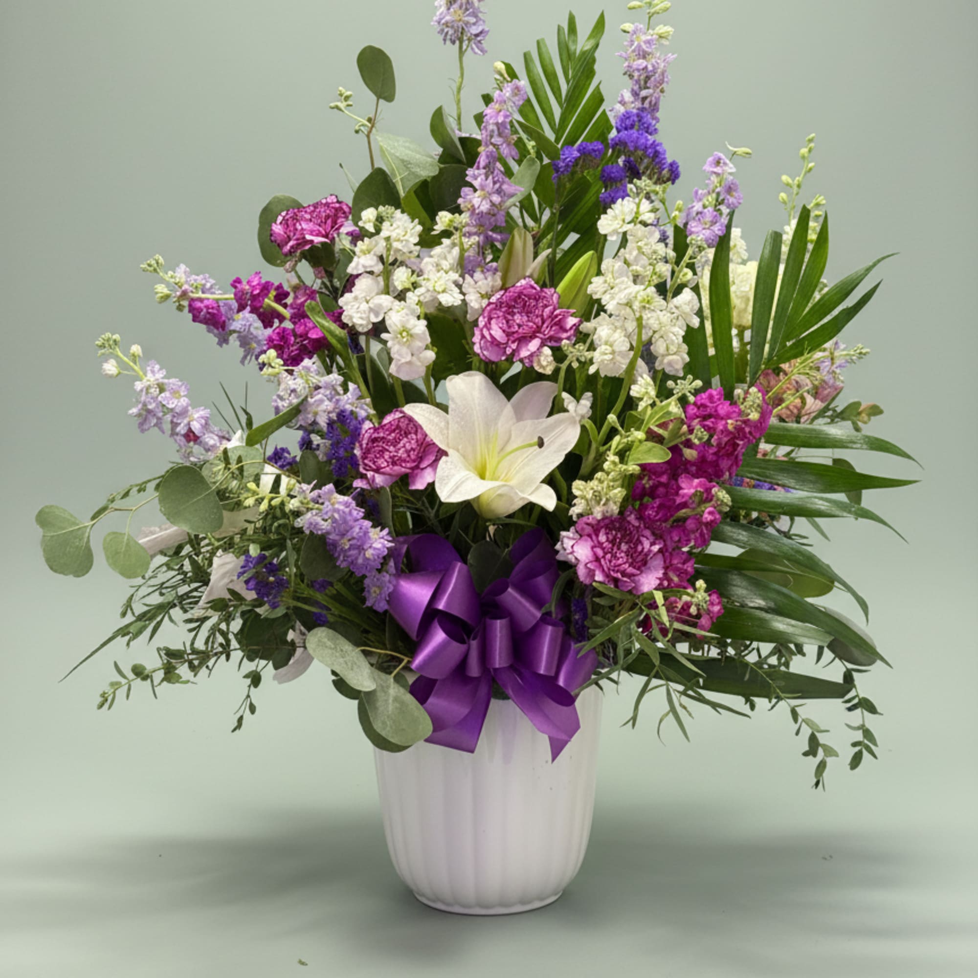 A luminous white lily takes center stage in this Shades of purple