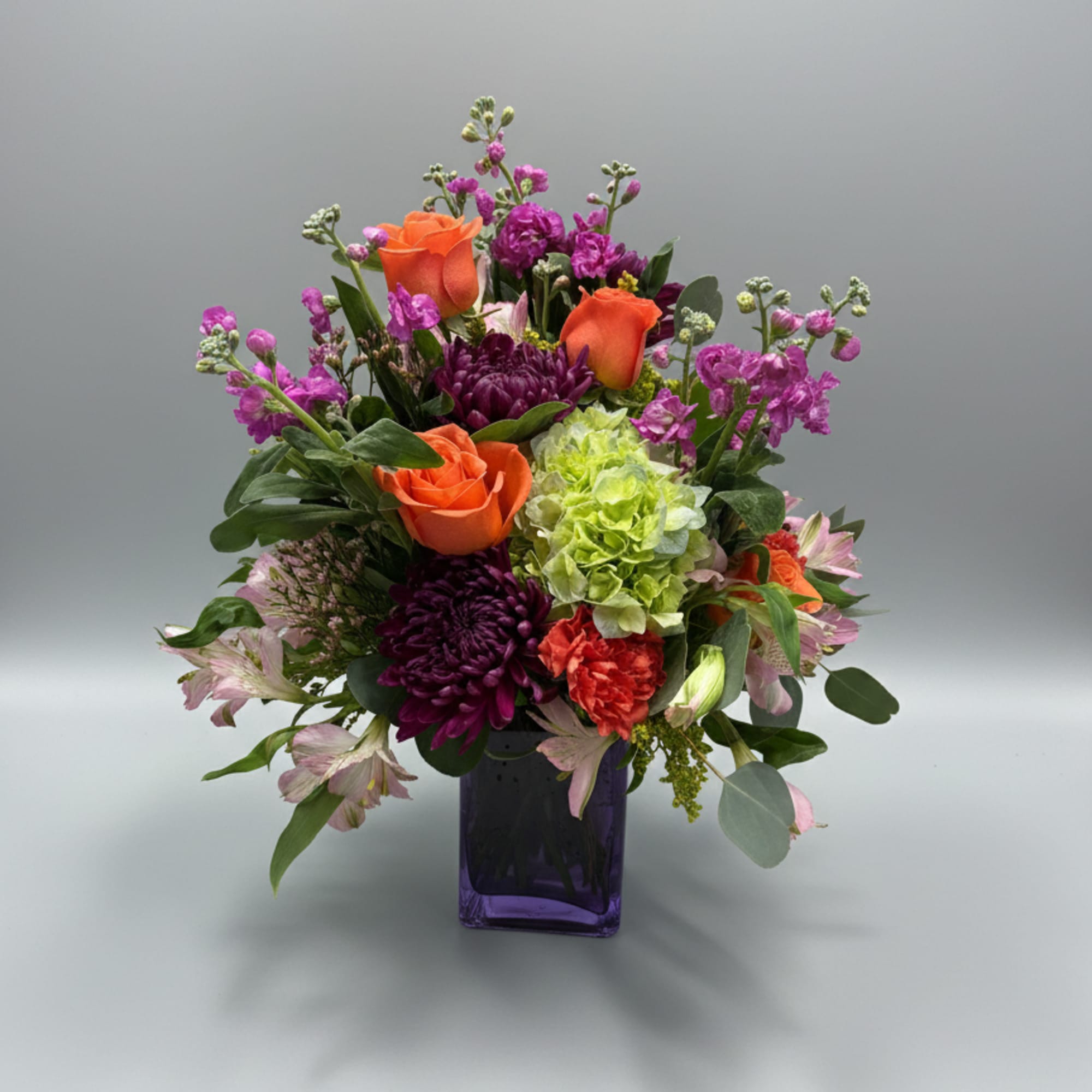 Bright bursts of orange roses meet vivid purple blooms and a lime-green, photo 3 of 3