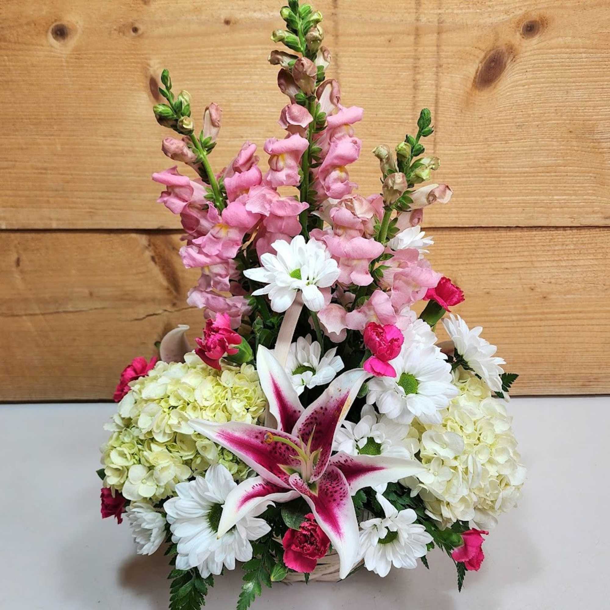 Mixed bouquet with pink snapdragons, white daisies, hydrangeas, and a pink lily
